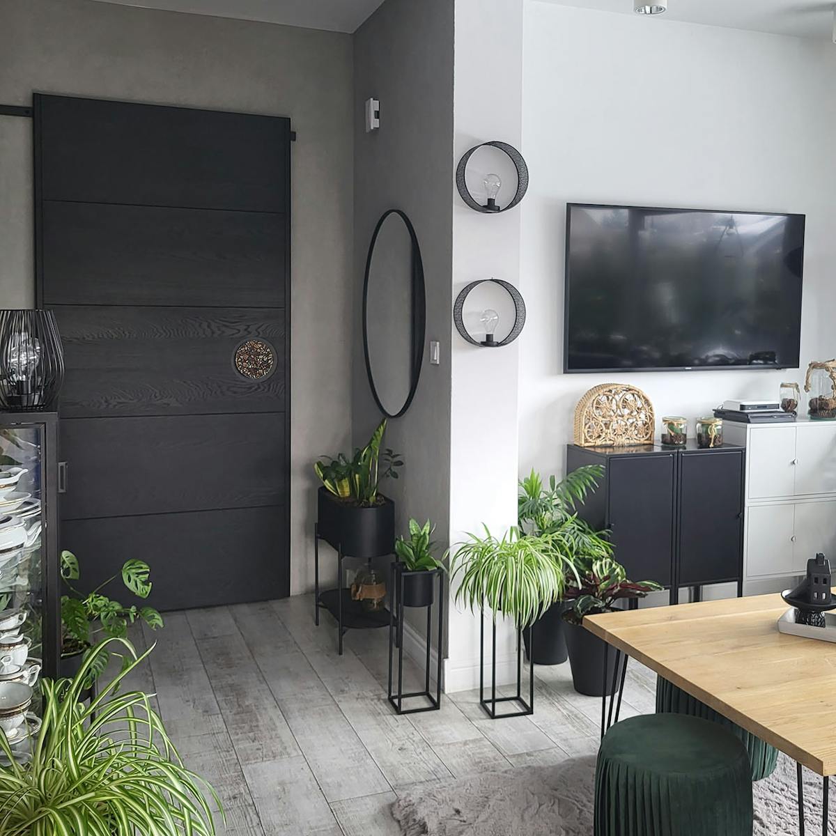 Schwarze Schiebetüren in einem modernen Wohnzimmer, das in grauen Farben mit schwarzen Accessoires dekoriert ist