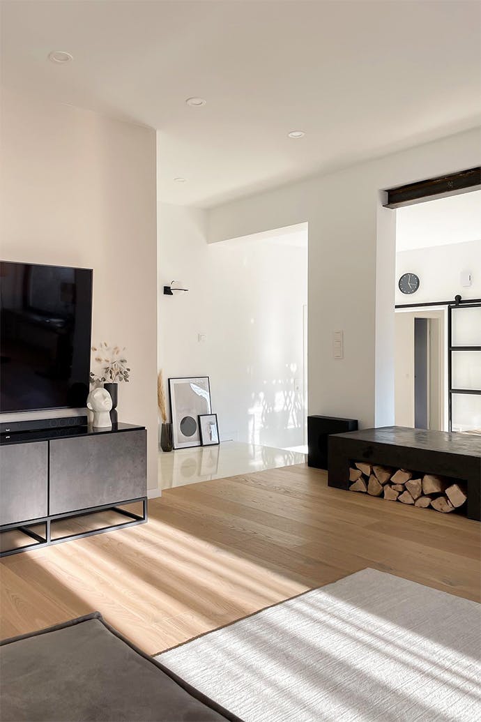 Un salon aux murs blancs et accessoires en métal noir dans un style minimaliste