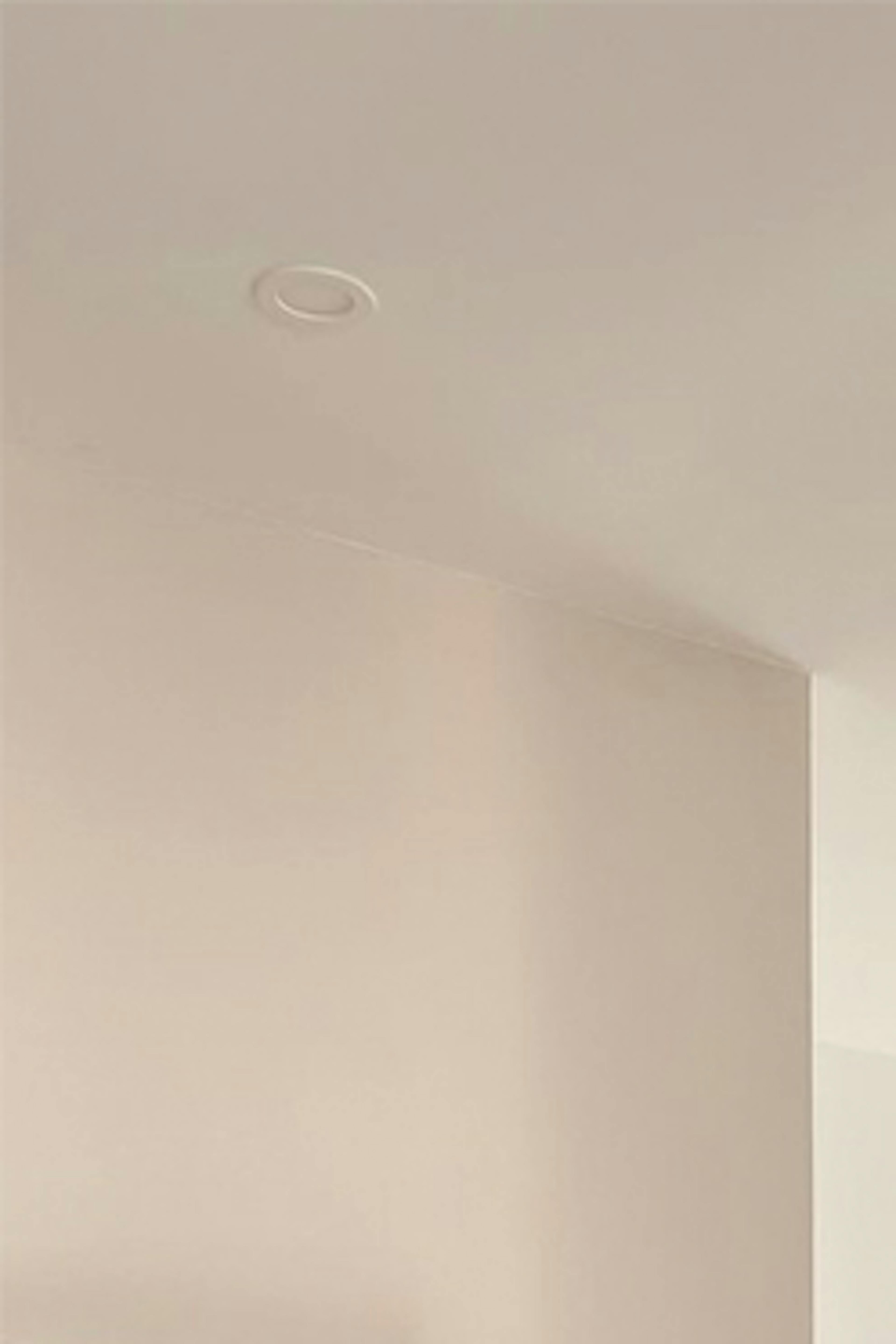 Un salon aux murs blancs et accessoires en métal noir dans un style minimaliste