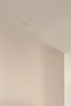 Un salon aux murs blancs et accessoires en métal noir dans un style minimaliste