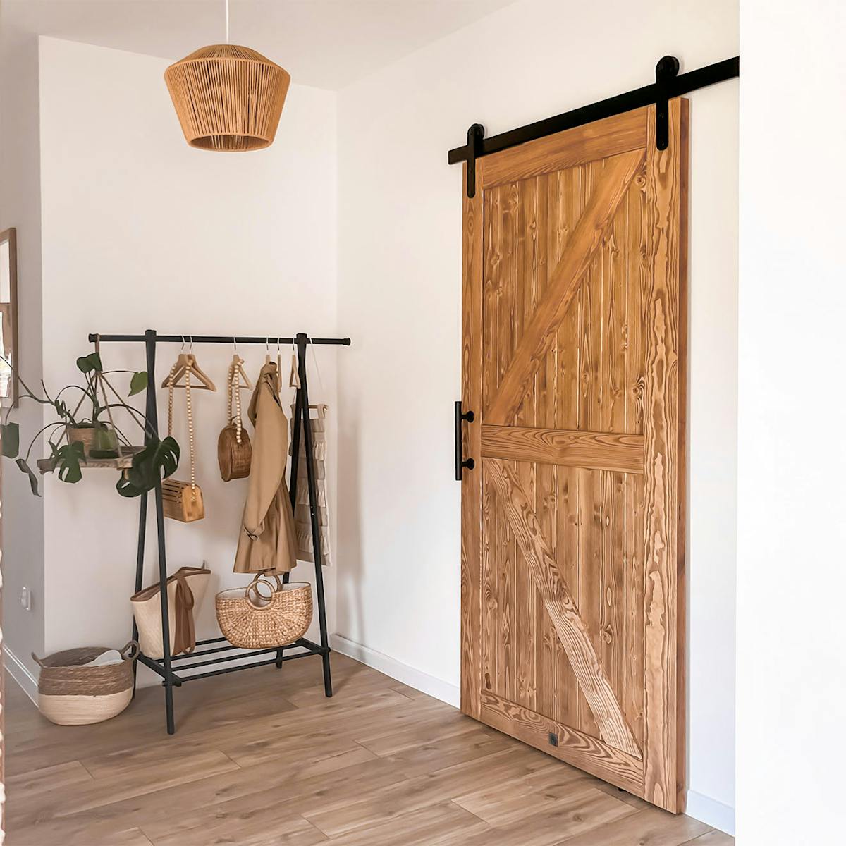 Metallregal mit Kleiderbügeln neben der Schiebetür im Flur