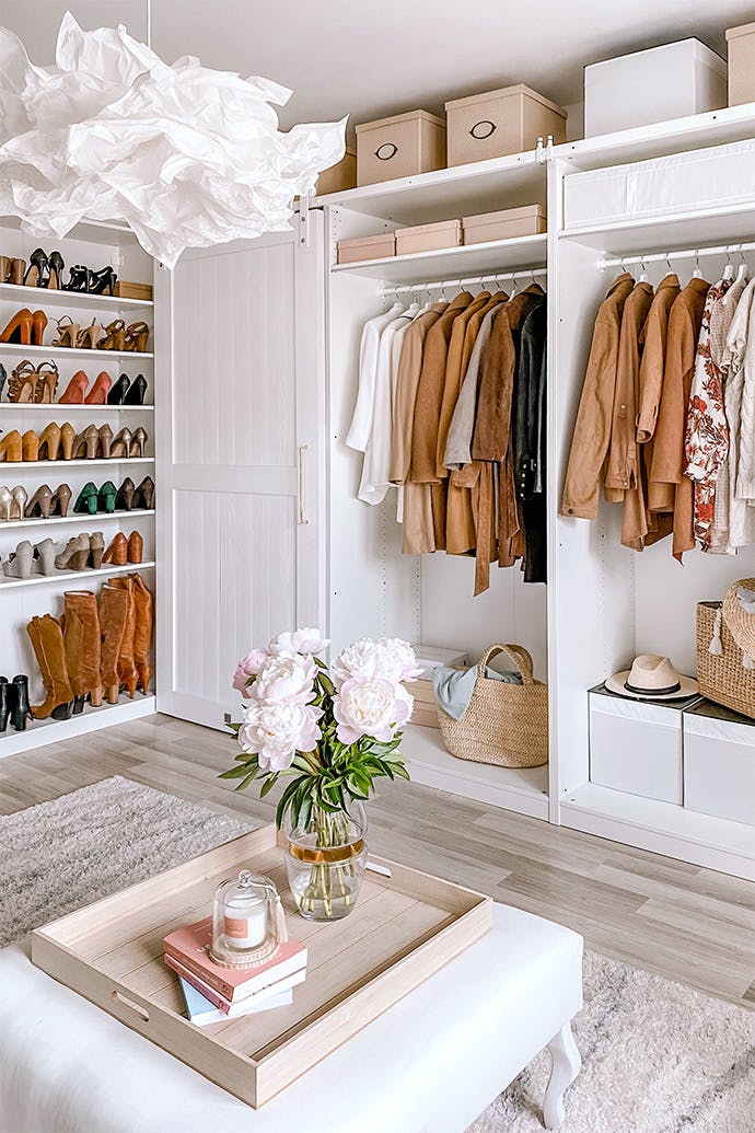 Grande pièce avec des armoires ouvertes montrant des vêtements et des étagères remplies de chaussures pour dames