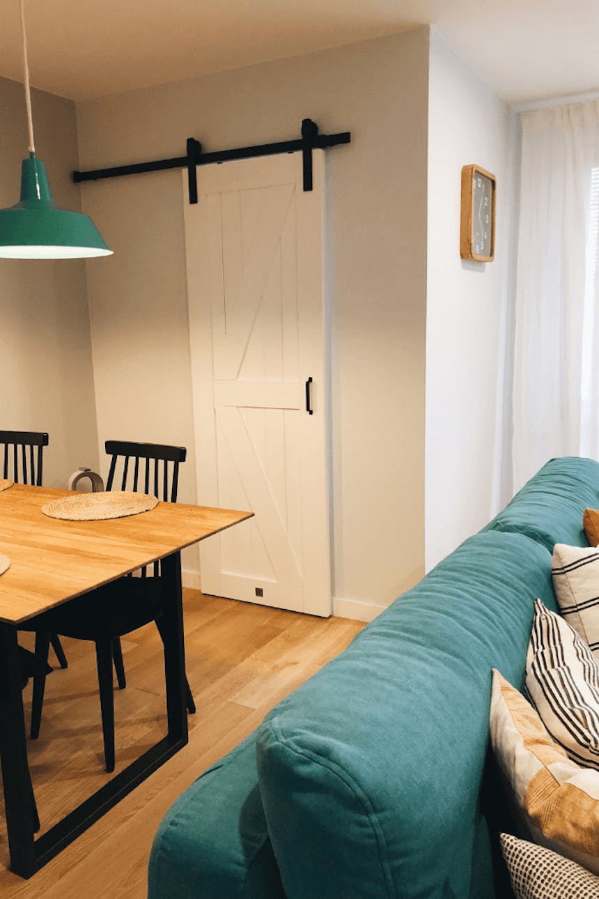 flaschengrün im Innenraum, weiße Schiebetür, industriellem Innenraum, Metallzubehör im Innenraum, Holzschiebetür, grüne Sofa, grüne Hängelampe