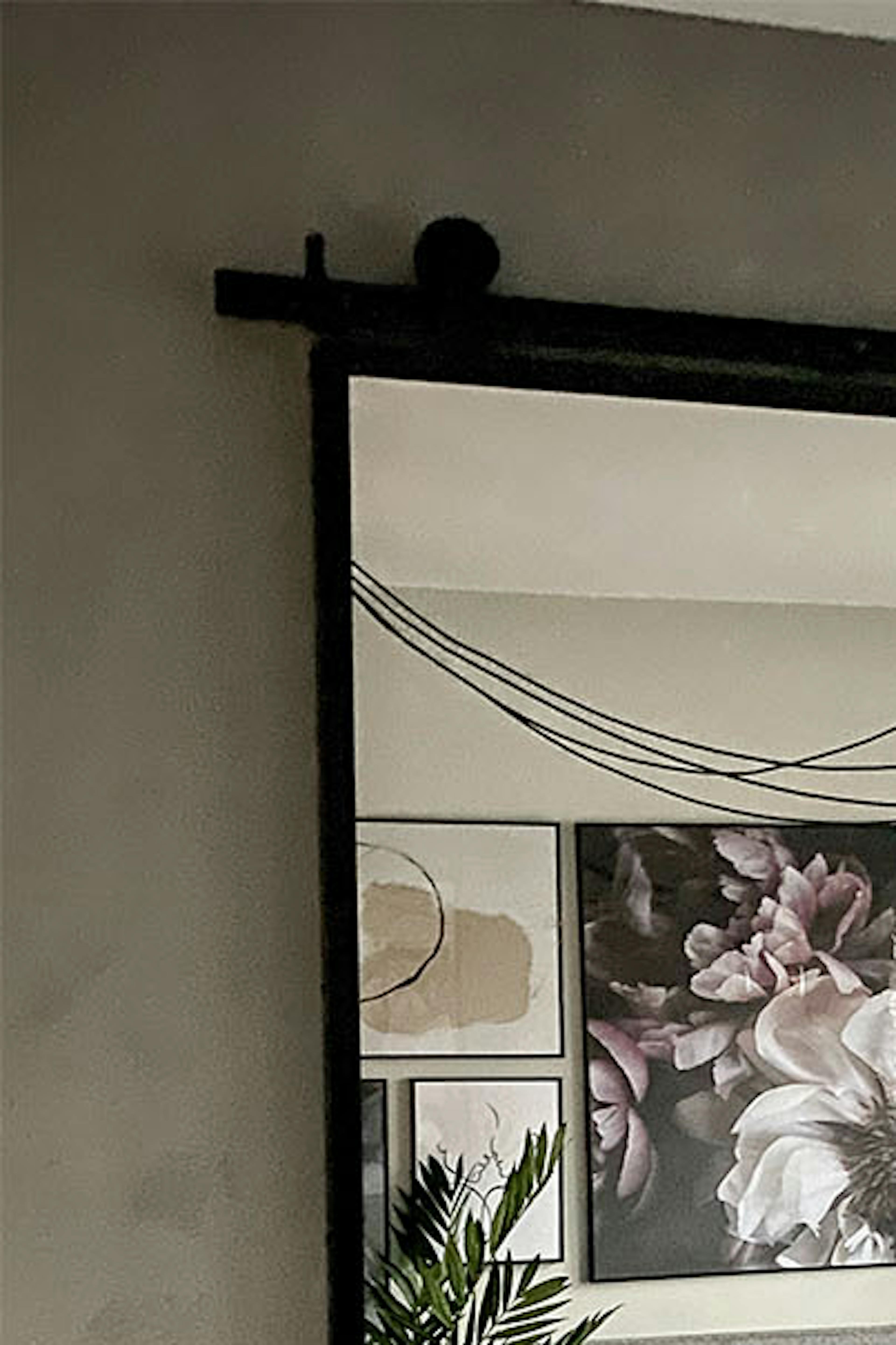 porte coulissante avec un miroir dans un cadre en métal sur un mur gris dans une chambre de style loft aux couleurs grises
