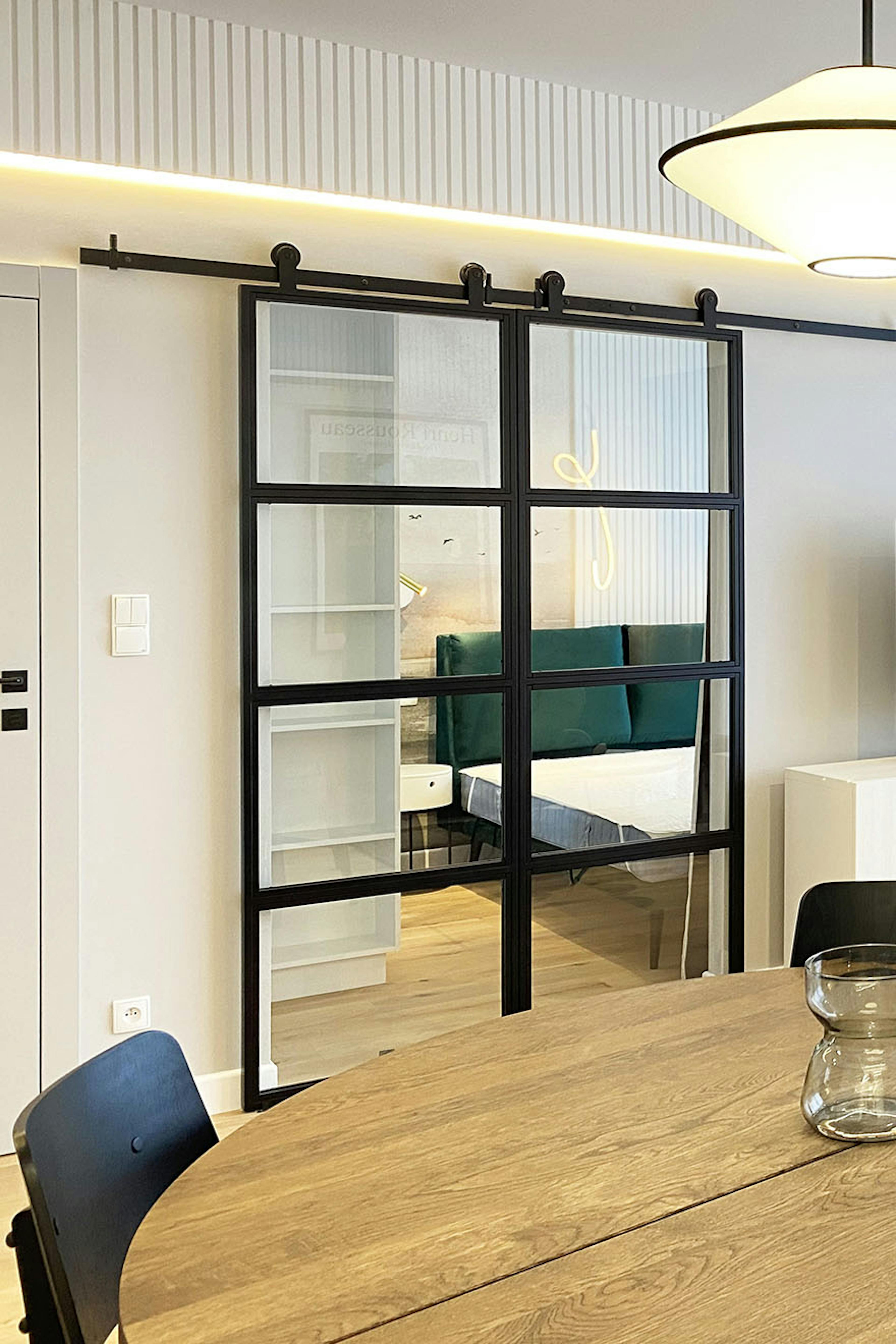 doubles portes coulissantes en métal et verre séparant le salon et la chambre