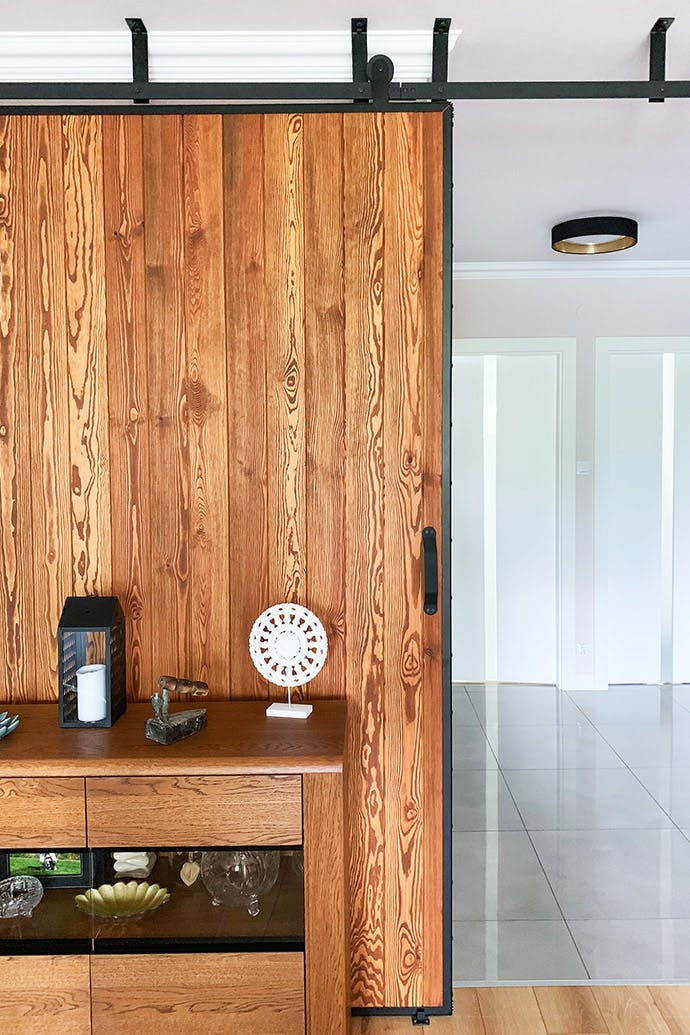 portes coulissantes en bois dans un cadre en métal sur un système de plafond noir