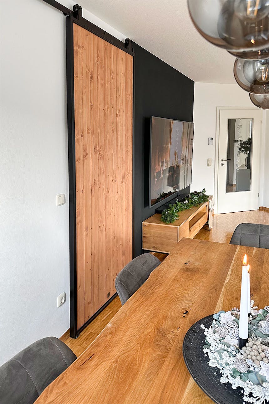 białe ściany, drewniana podłoga i drzwi przesuwne w salonie