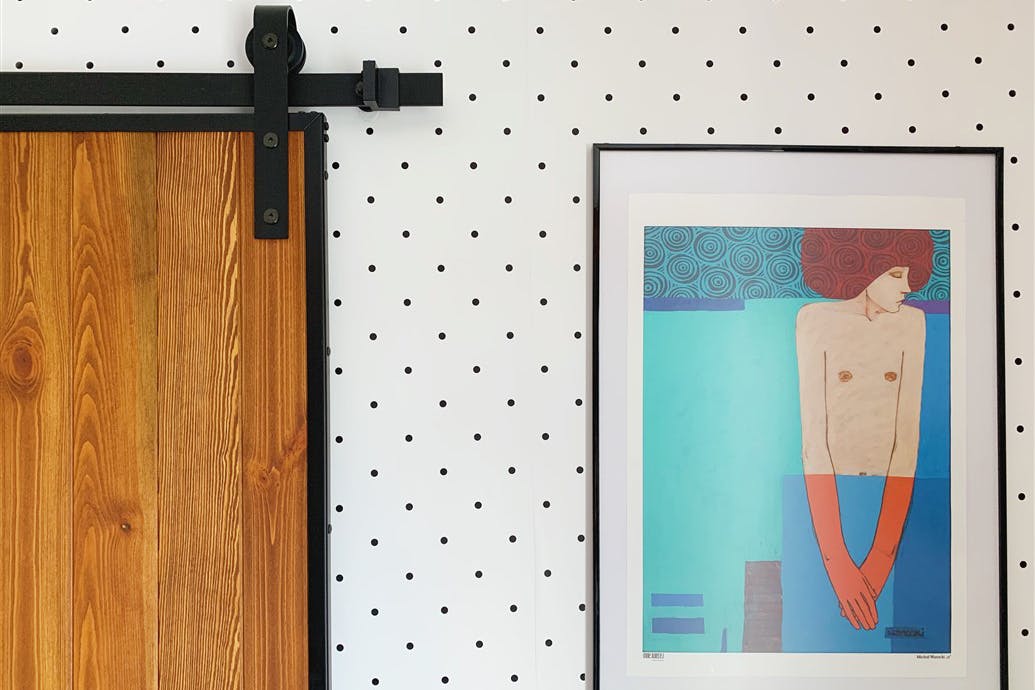 portes coulissantes en bois dans un cadre noir et une affiche décorative sur le mur à pois