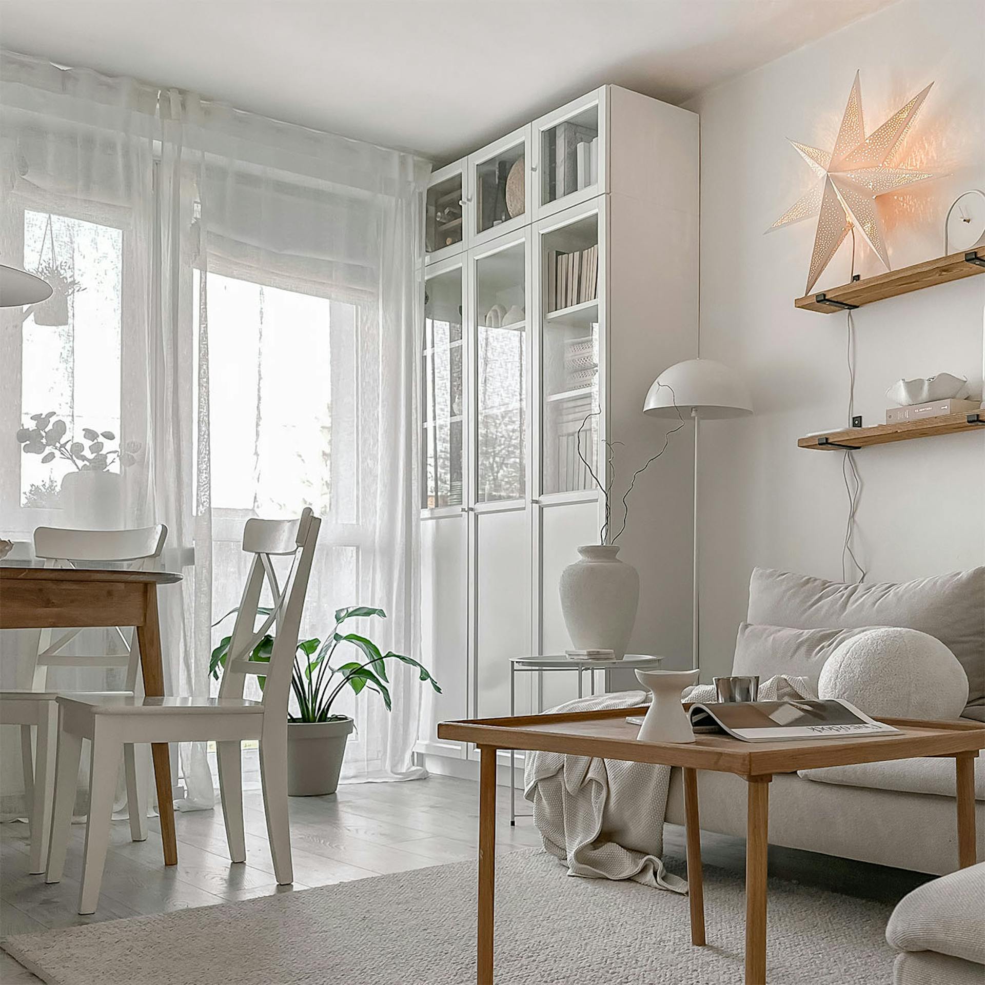 Couchtisch aus Holz, weißer Kleiderschrank mit Glasfronten im Wohnzimmer eines Wohnblocks