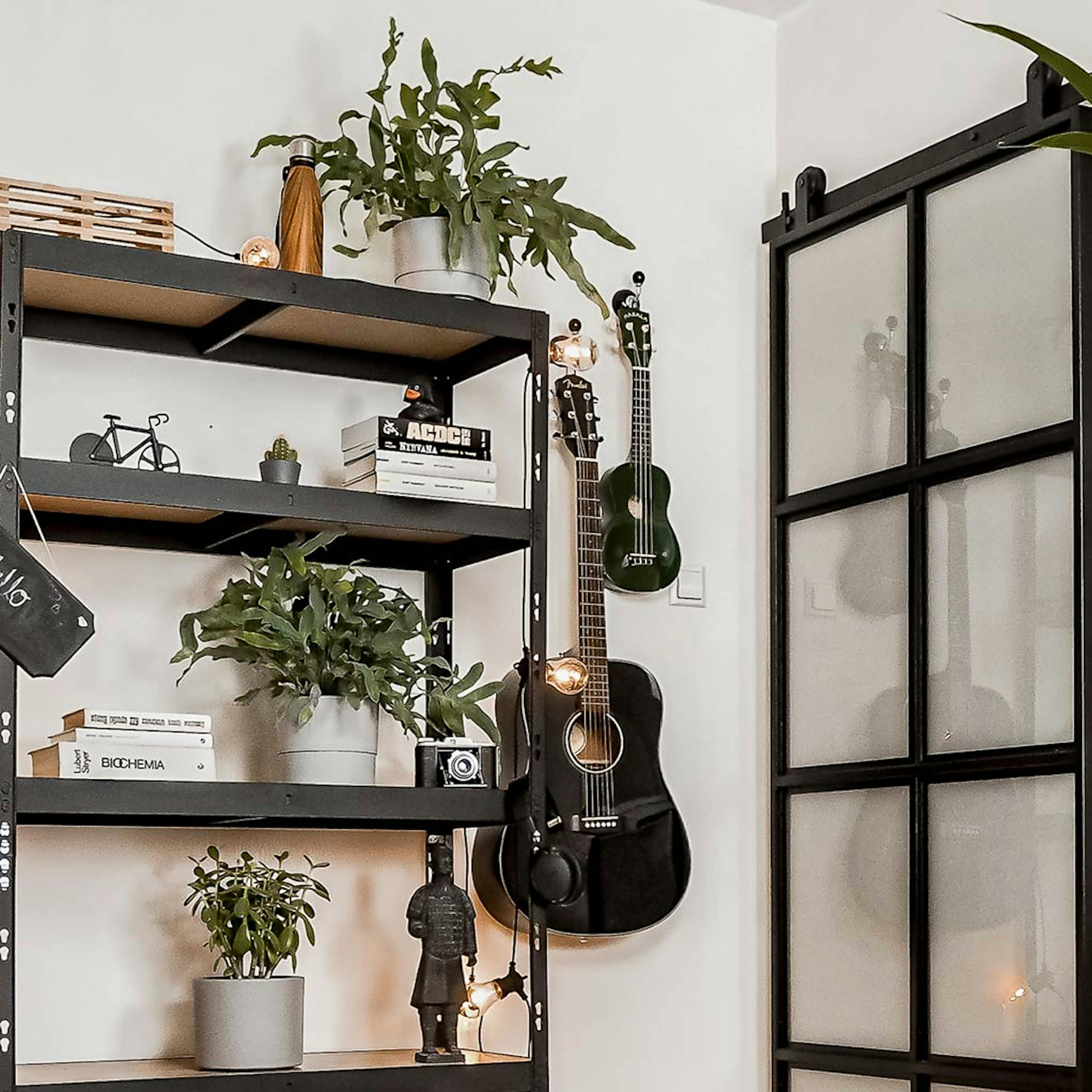 aménagement d'une chambre d'étudiant avec une bibliothèque loft et une porte coulissante en métal avec verre