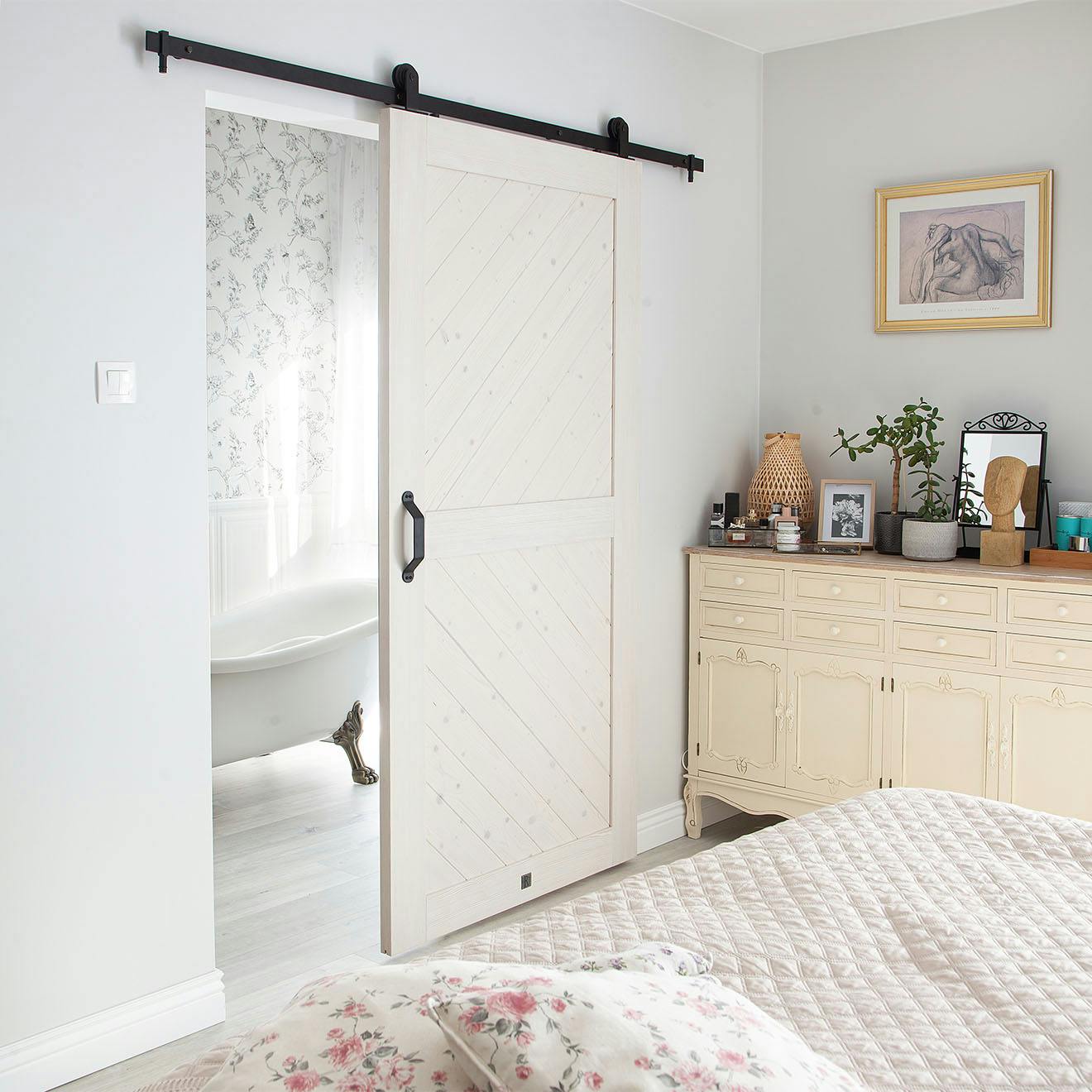 white wooden sliding door separating the bathroom from the Provence-style bedroom
