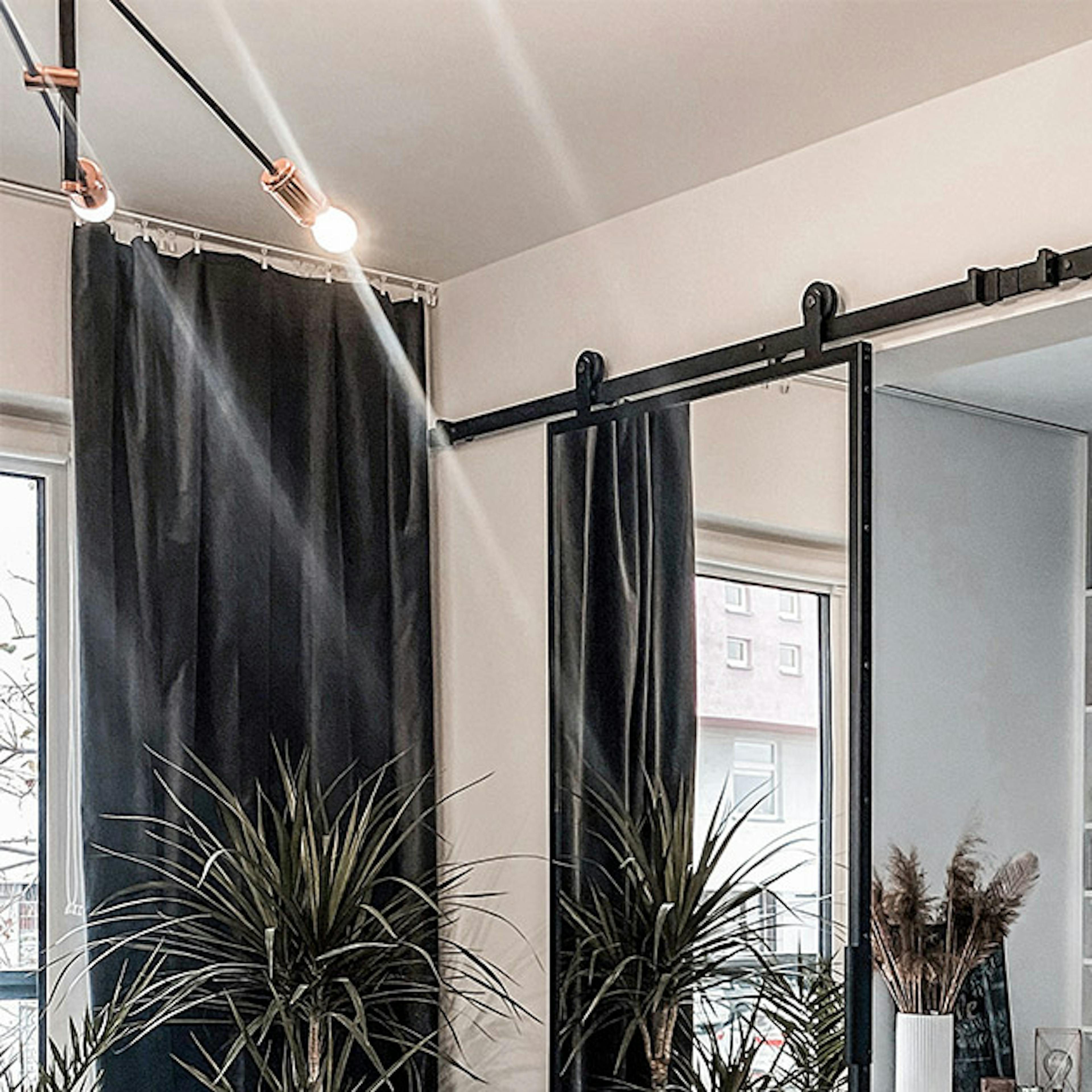 Une double porte coulissante ouverte avec un miroir montrant un fragment d'une armoire avec une coiffeuse blanche