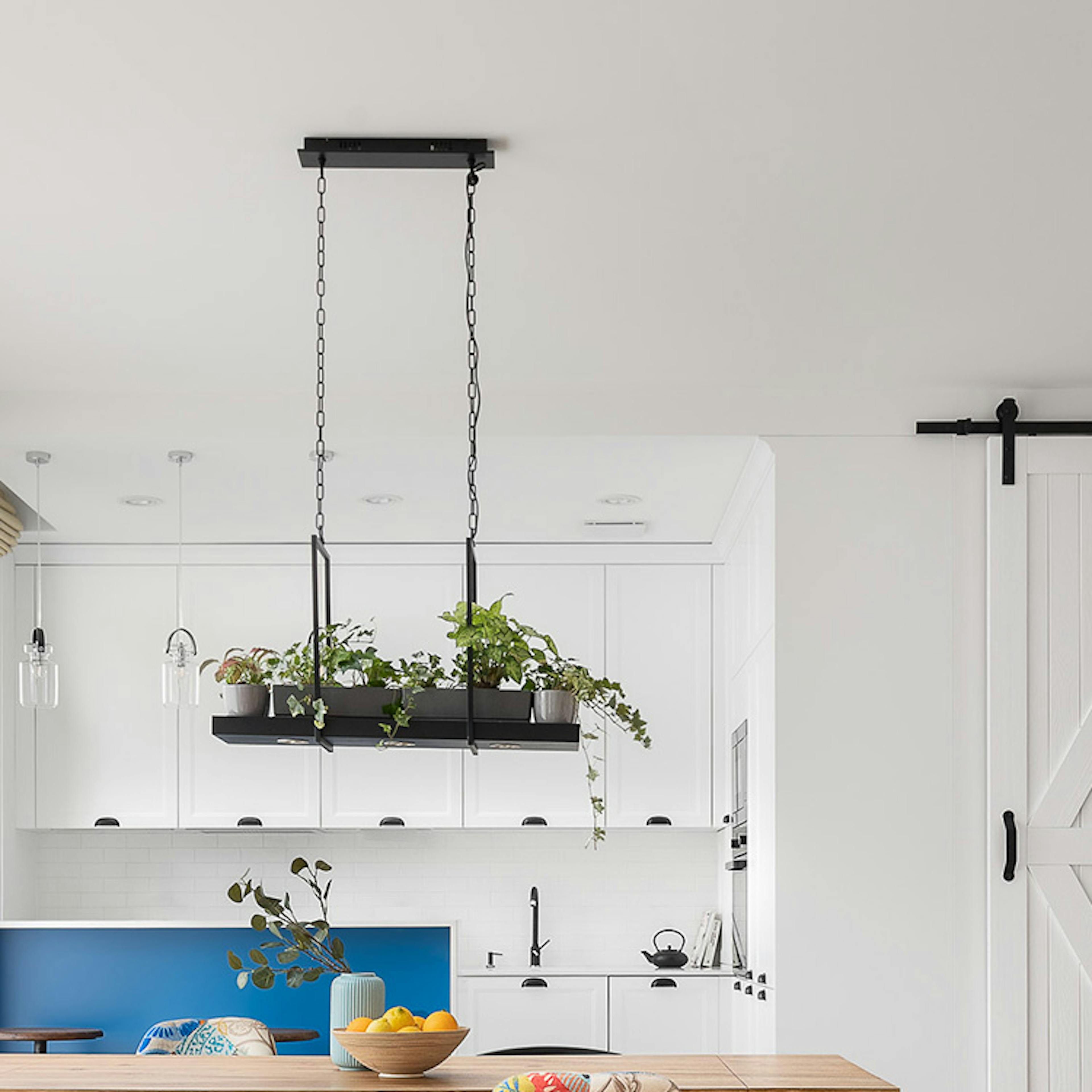 Un salon lumineux combiné à une salle à manger et une cuisine, décoré en blanc et bois dans le style côtier californien