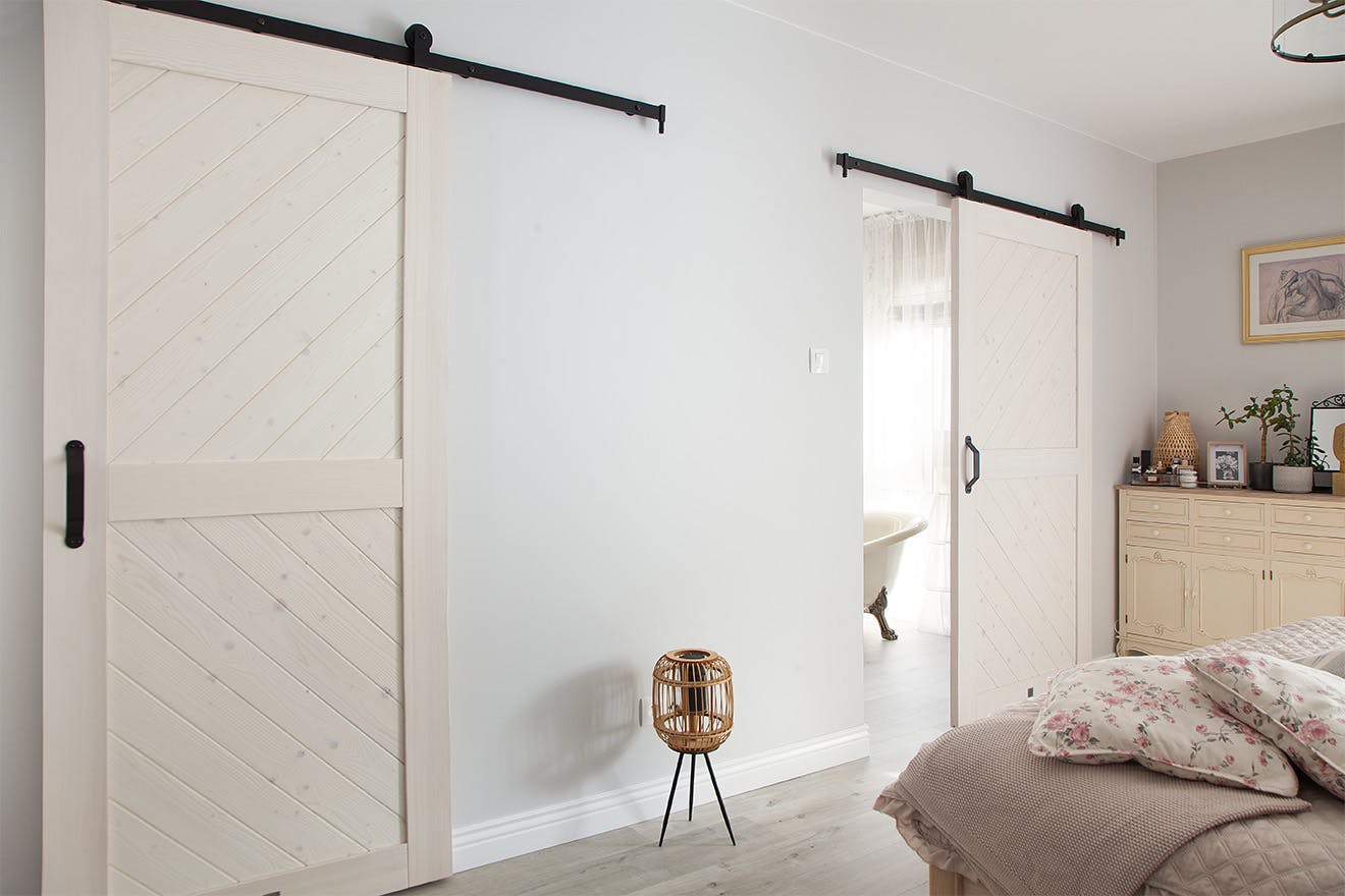 white sliding door to the bathroom in a bedroom decorated in Provencal style