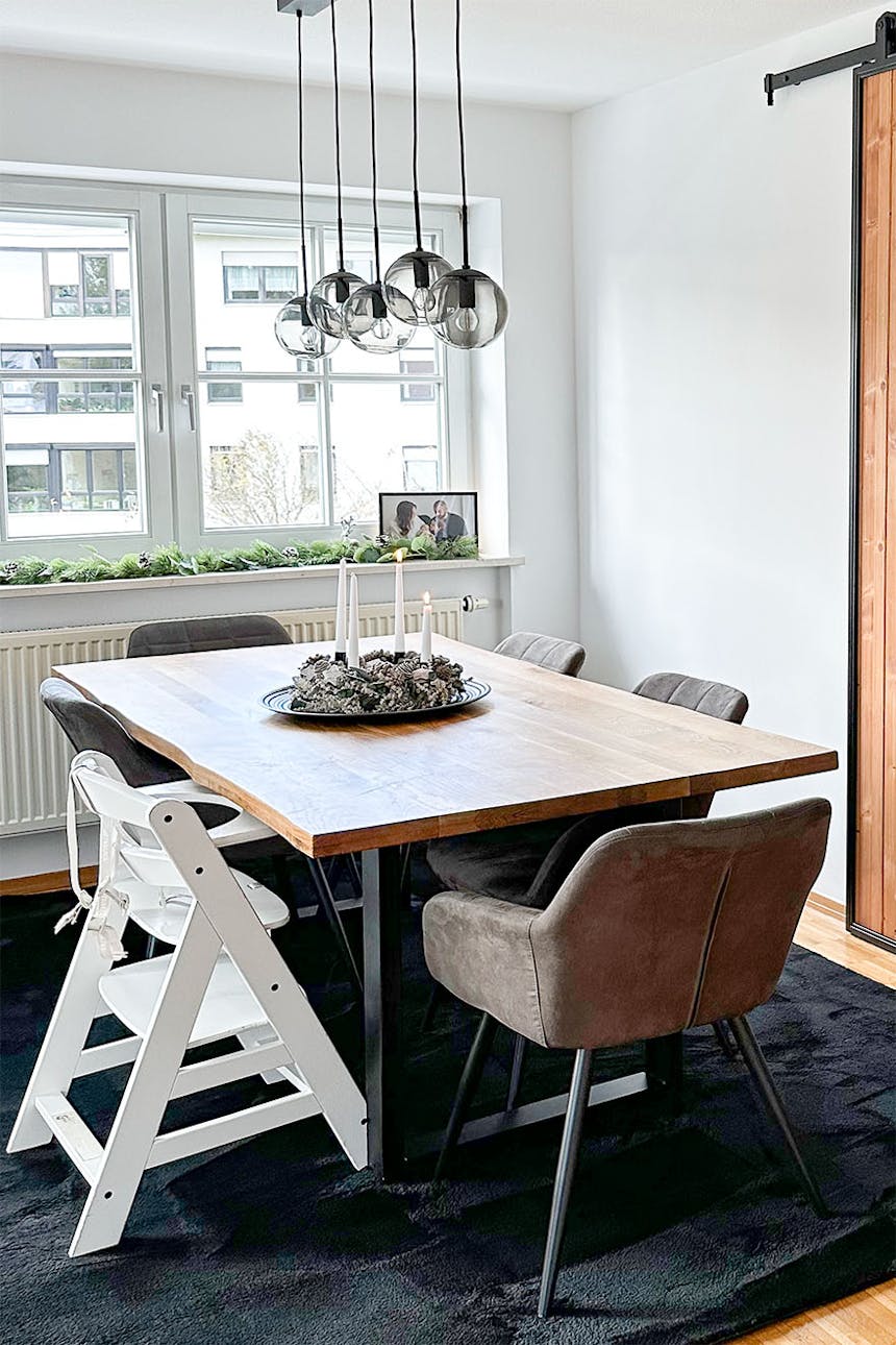 duży stół jadalniany z drewnianym blatem ustawiony obok okna w salonie