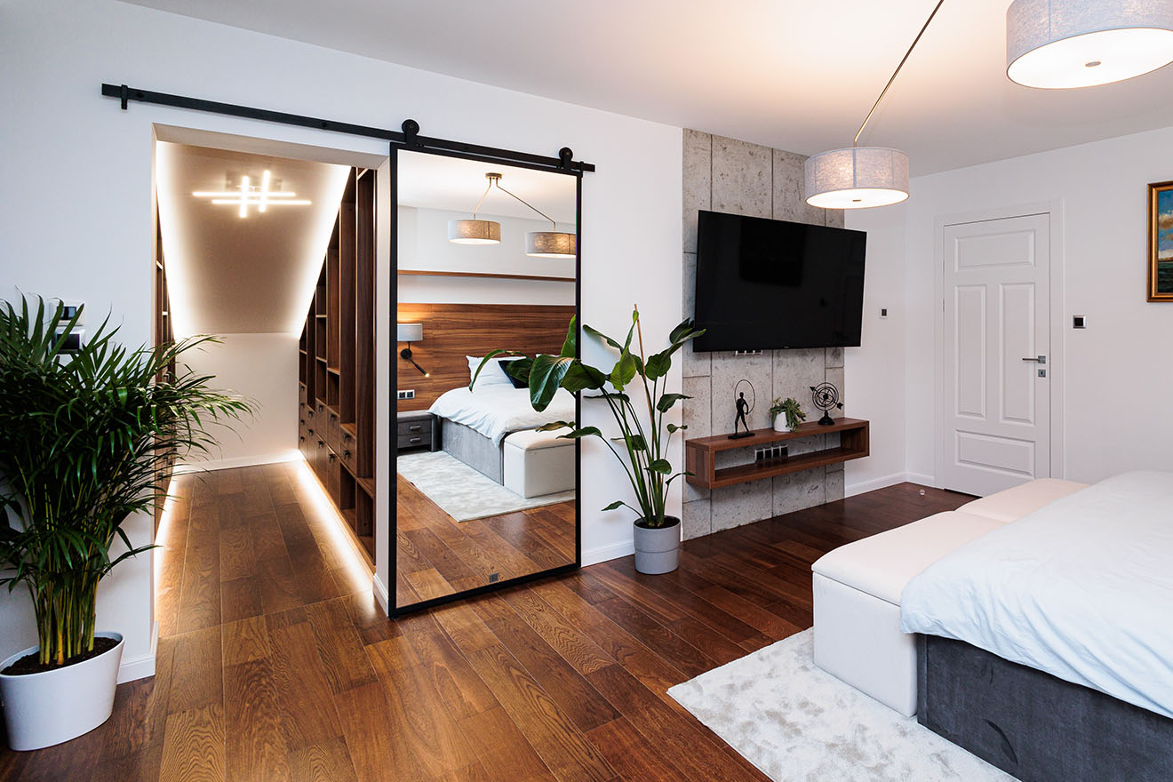 sypialnia w stylu hotelowym z garderobą i dużym lustrem przesuwnym