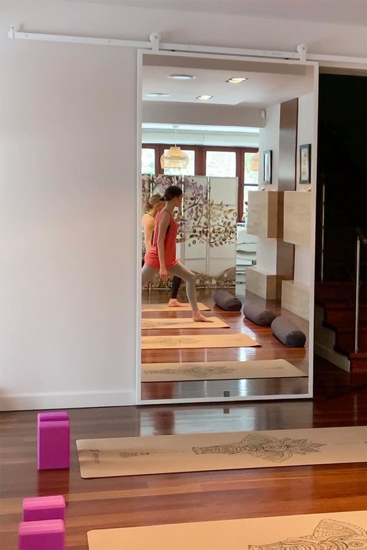 Schiebetür mit Spiegel in einem weißen Rahmen in einem Yogastudio