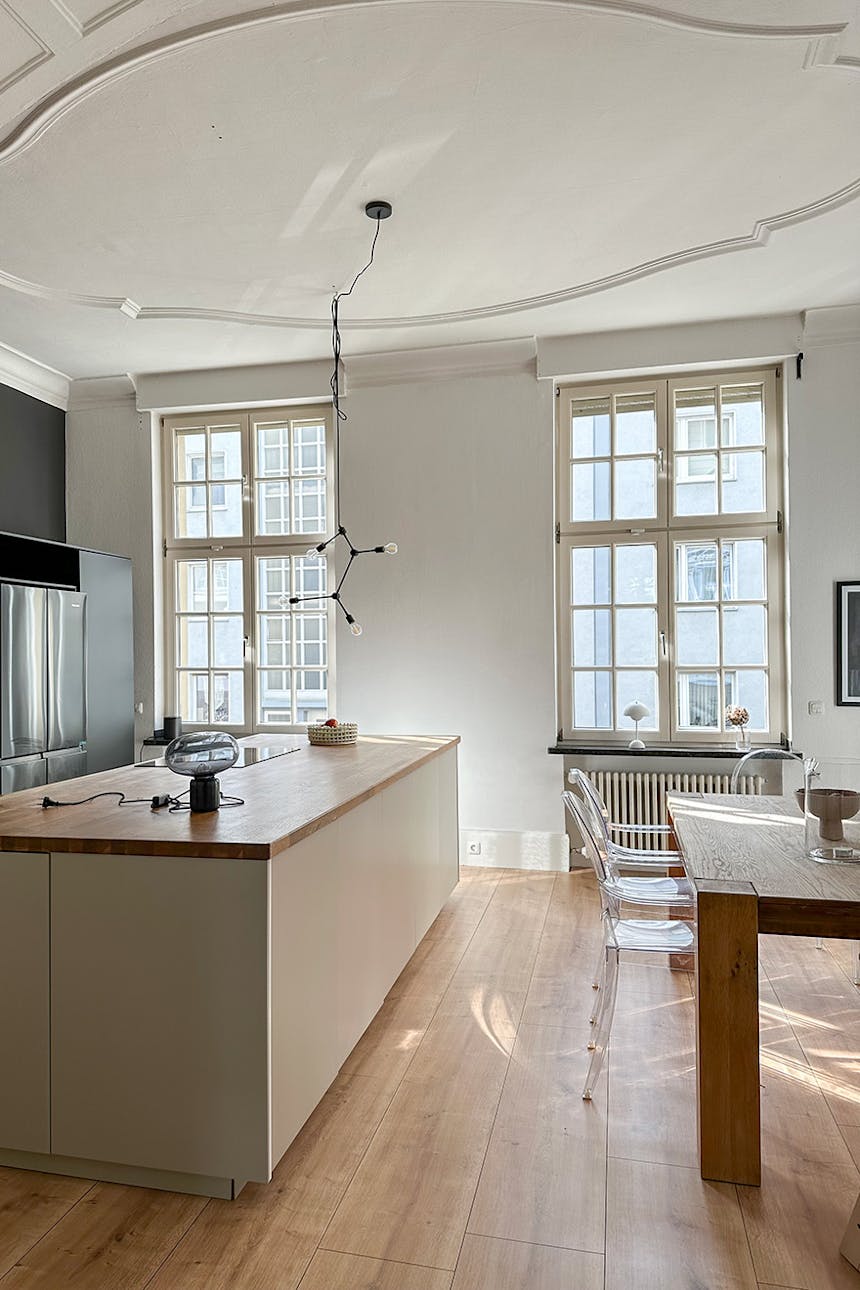 minimalistyczna kuchnia z dużymi oknami i sztukaterią na suficie