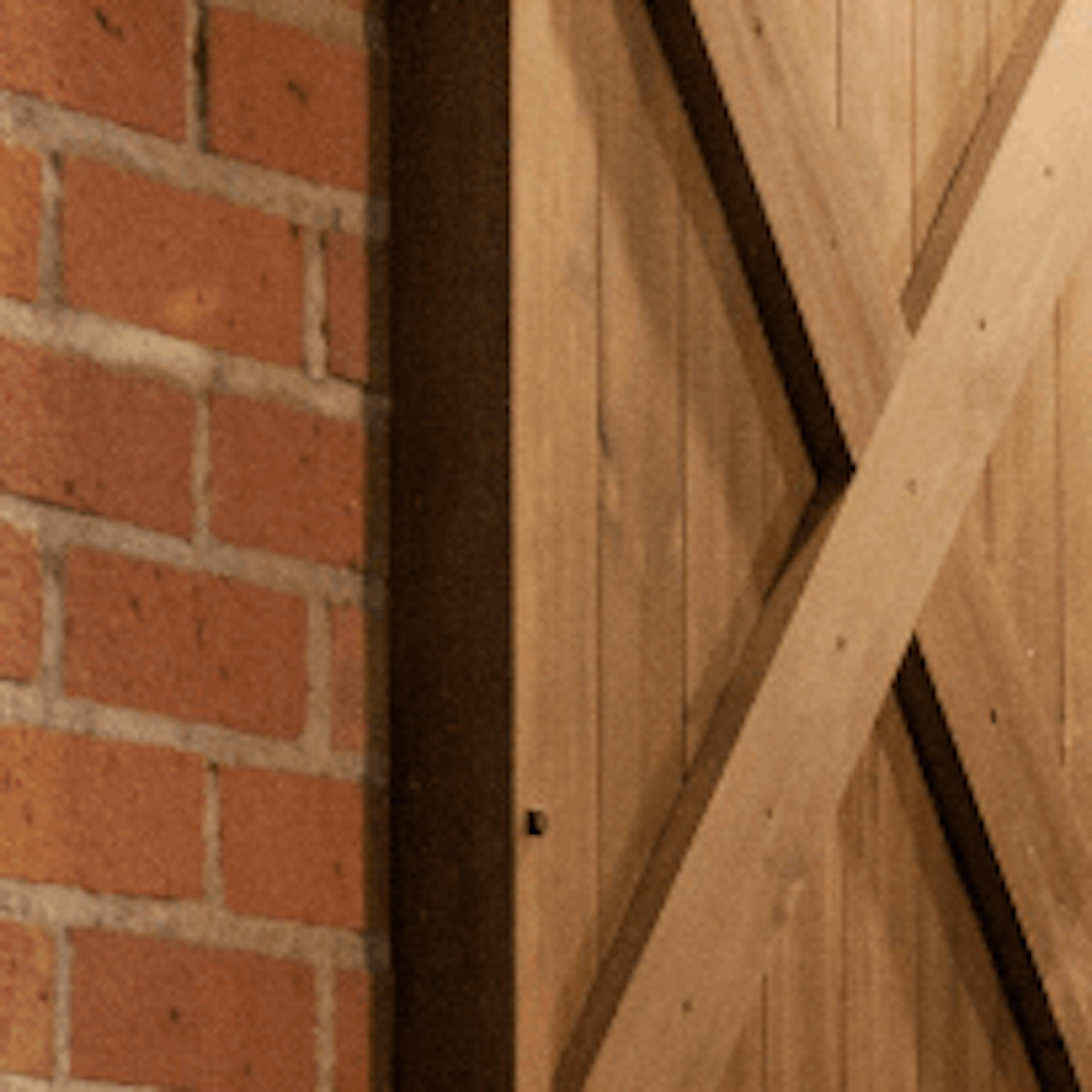 porte coulissante en bois massif sur mur de briques