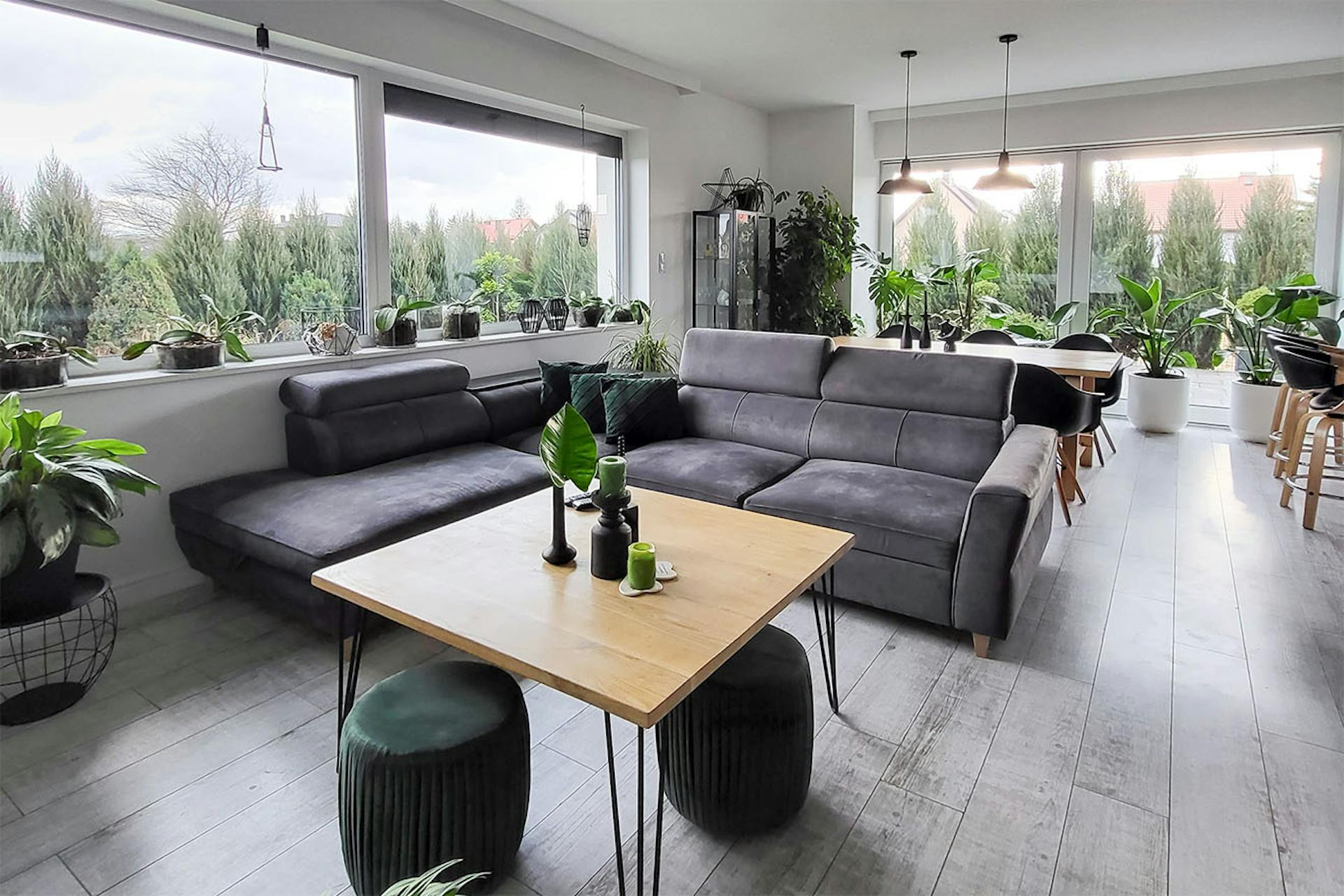 ein Wohnzimmer mit einem grauen Sofa und einem quadratischen Couchtisch aus Holz in einem grau-schwarzen Arrangement