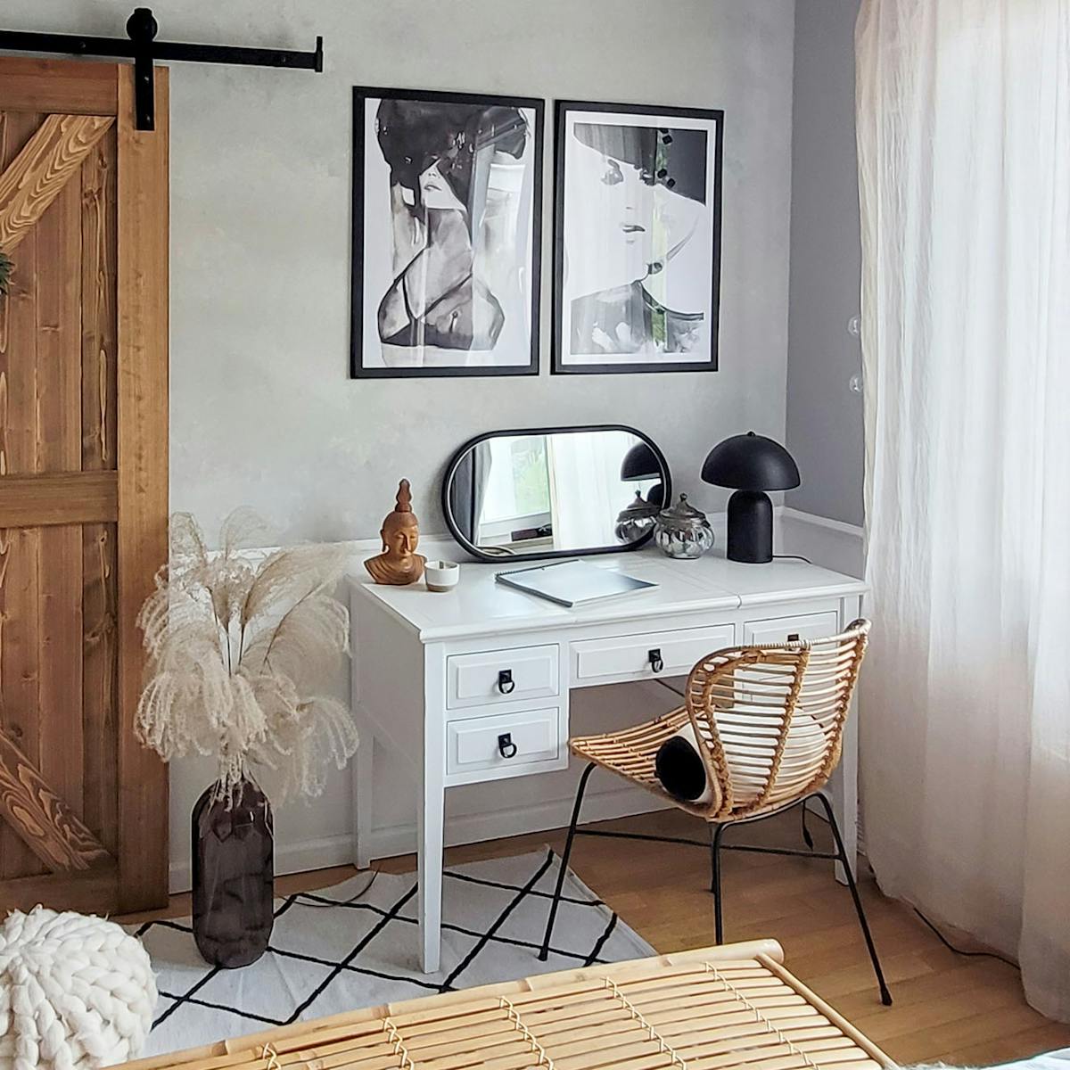 czarno białe plakaty nad białą toaletką z lustrem