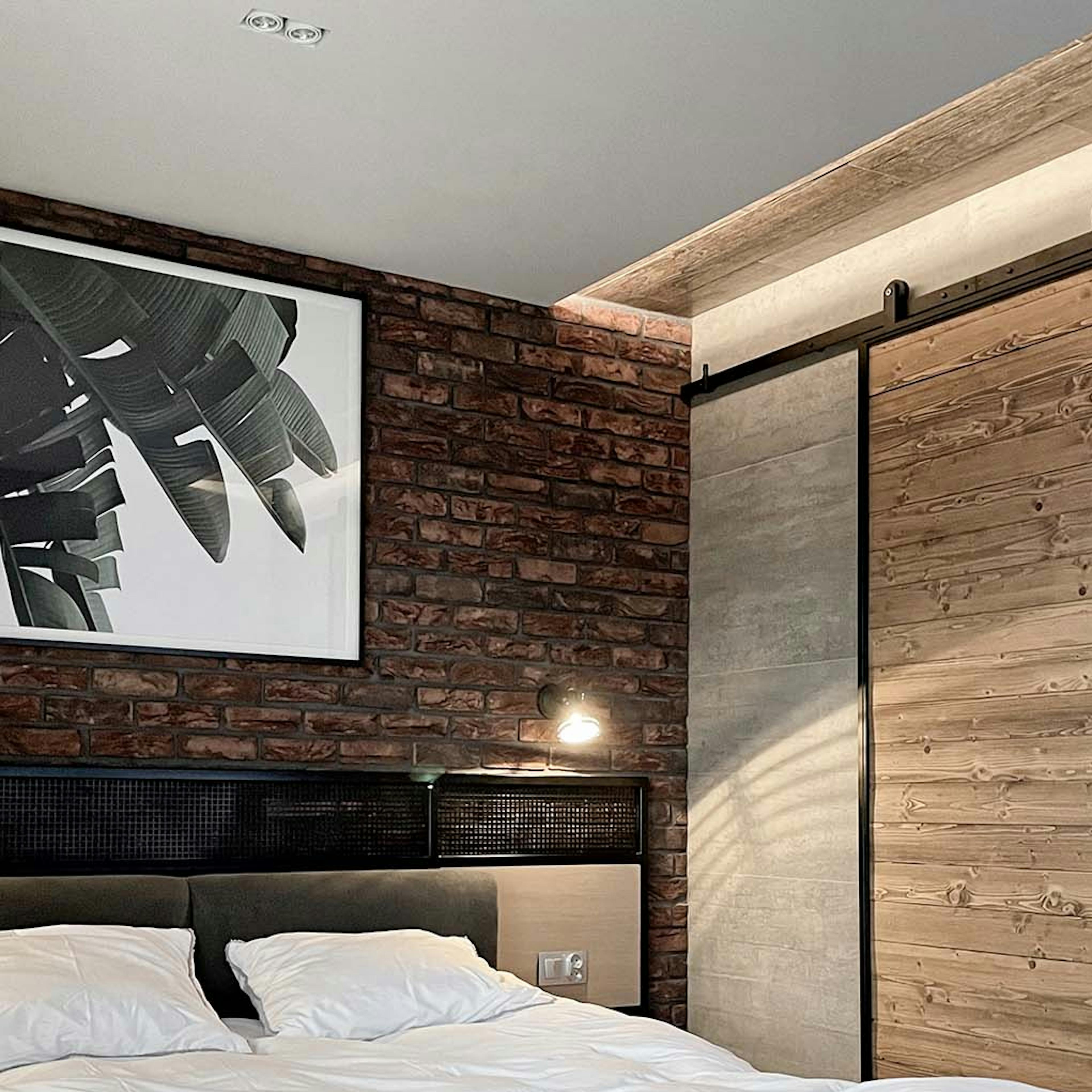 portes coulissantes à côté d'un grand lit dans une chambre de style loft