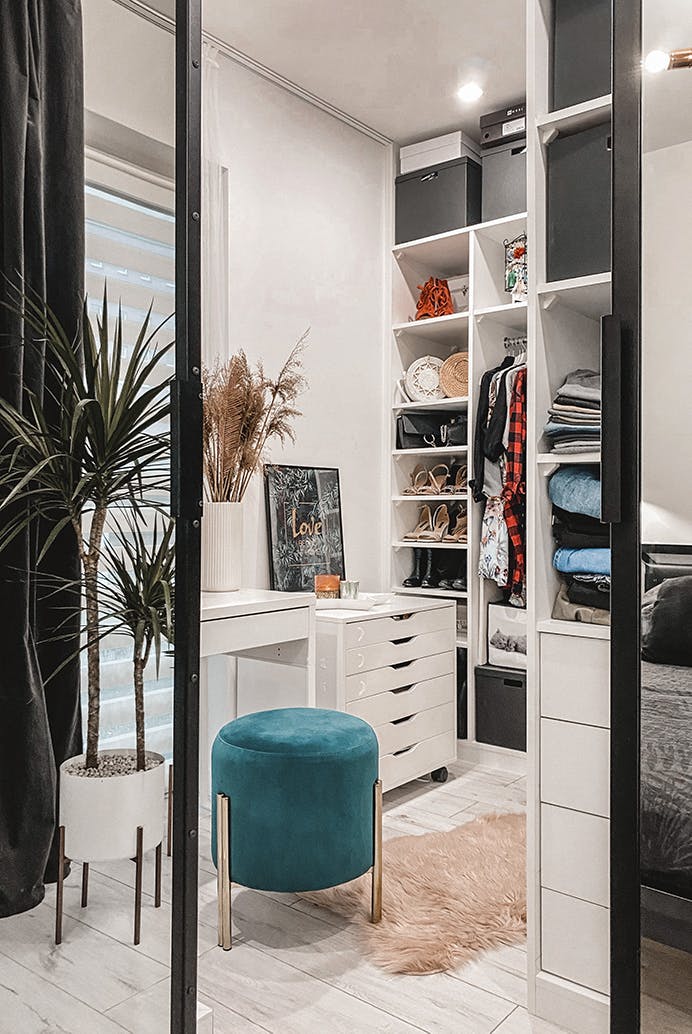Un dressing décoré dans un style moderne avec une coiffeuse et des meubles blancs