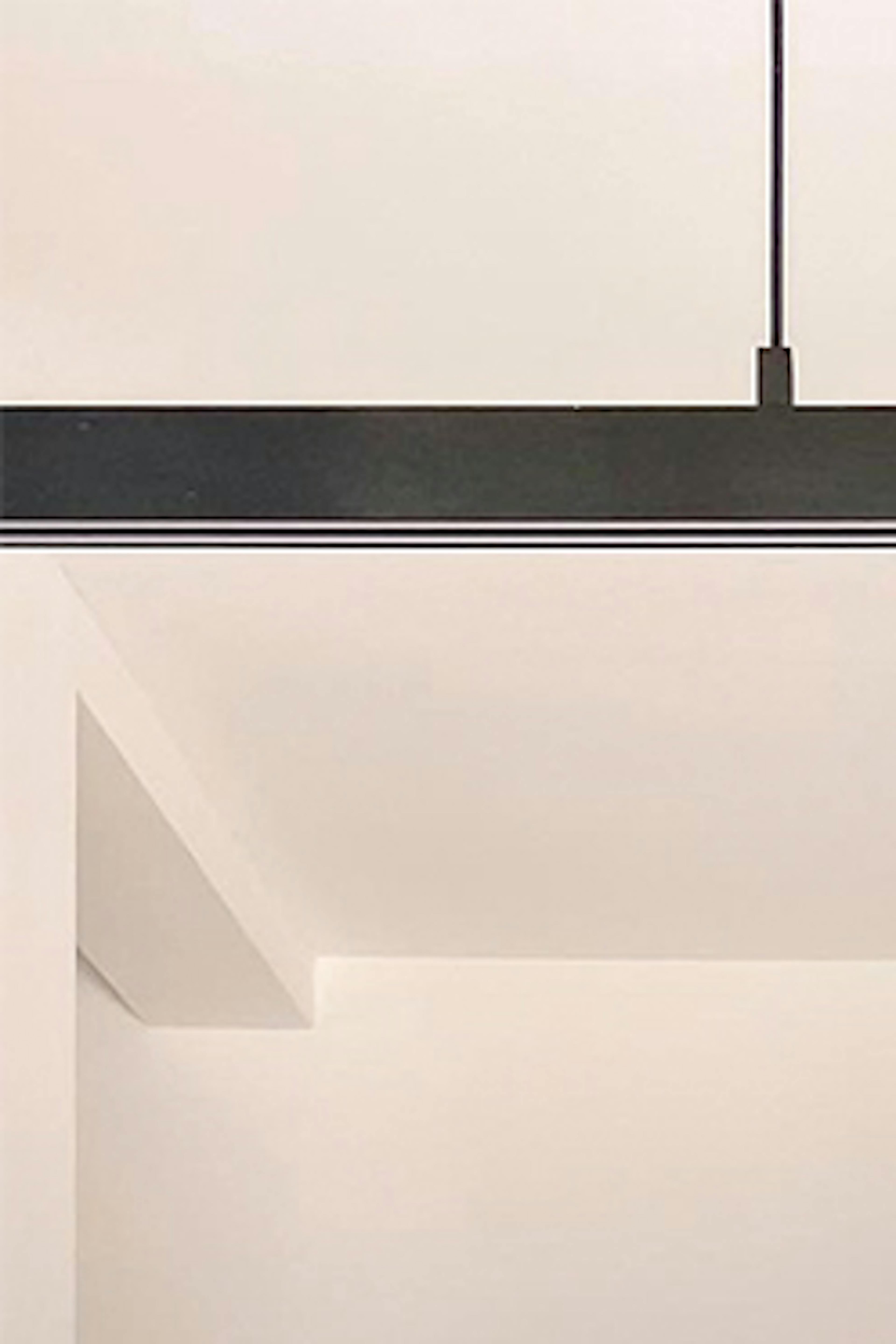 Vases décoratifs sur une grande table à manger éclairée par une longue lampe minimaliste