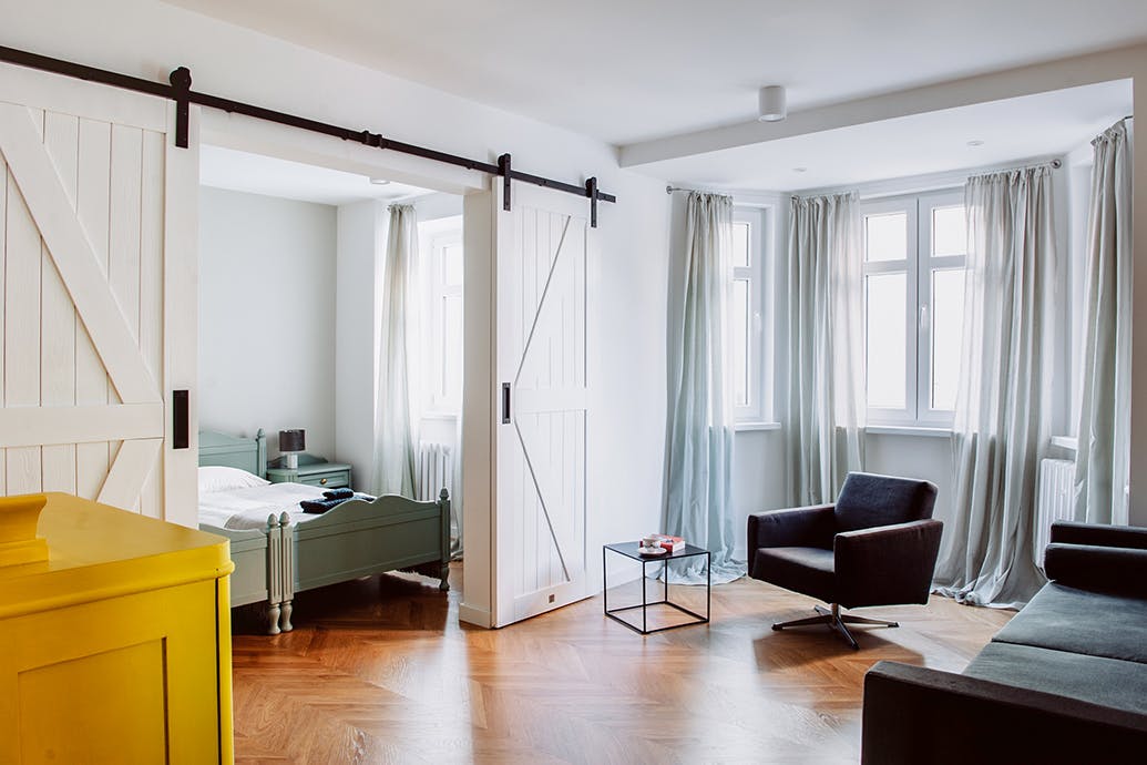 portes coulissantes doubles blanches séparant le salon et la chambre dans l'appartement à louer