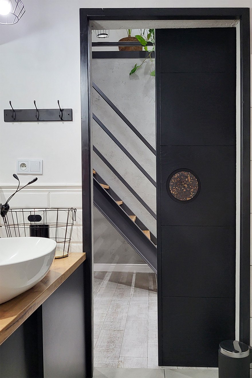 Schwarze Tür, die das Badezimmer vom Flur trennt