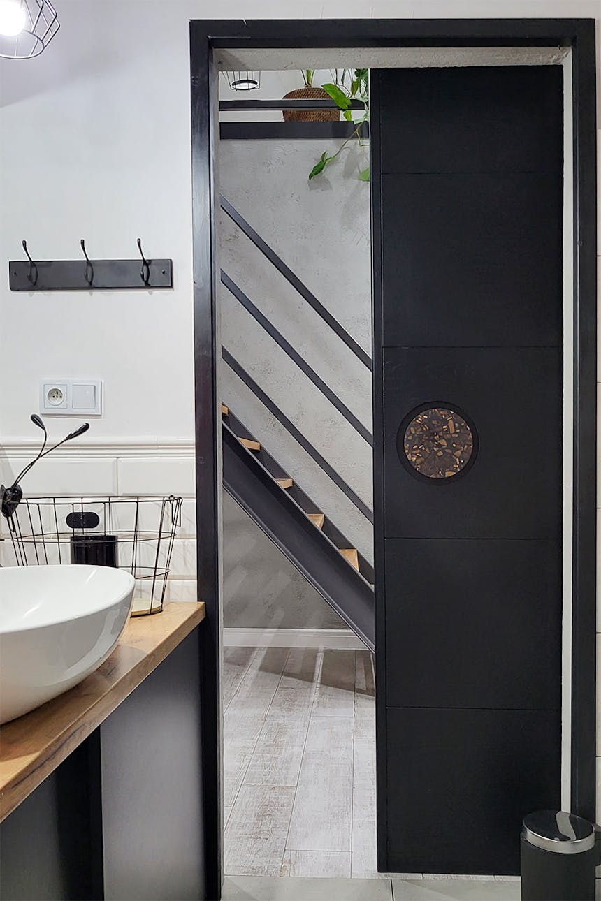 Schwarze Tür, die das Badezimmer vom Flur trennt