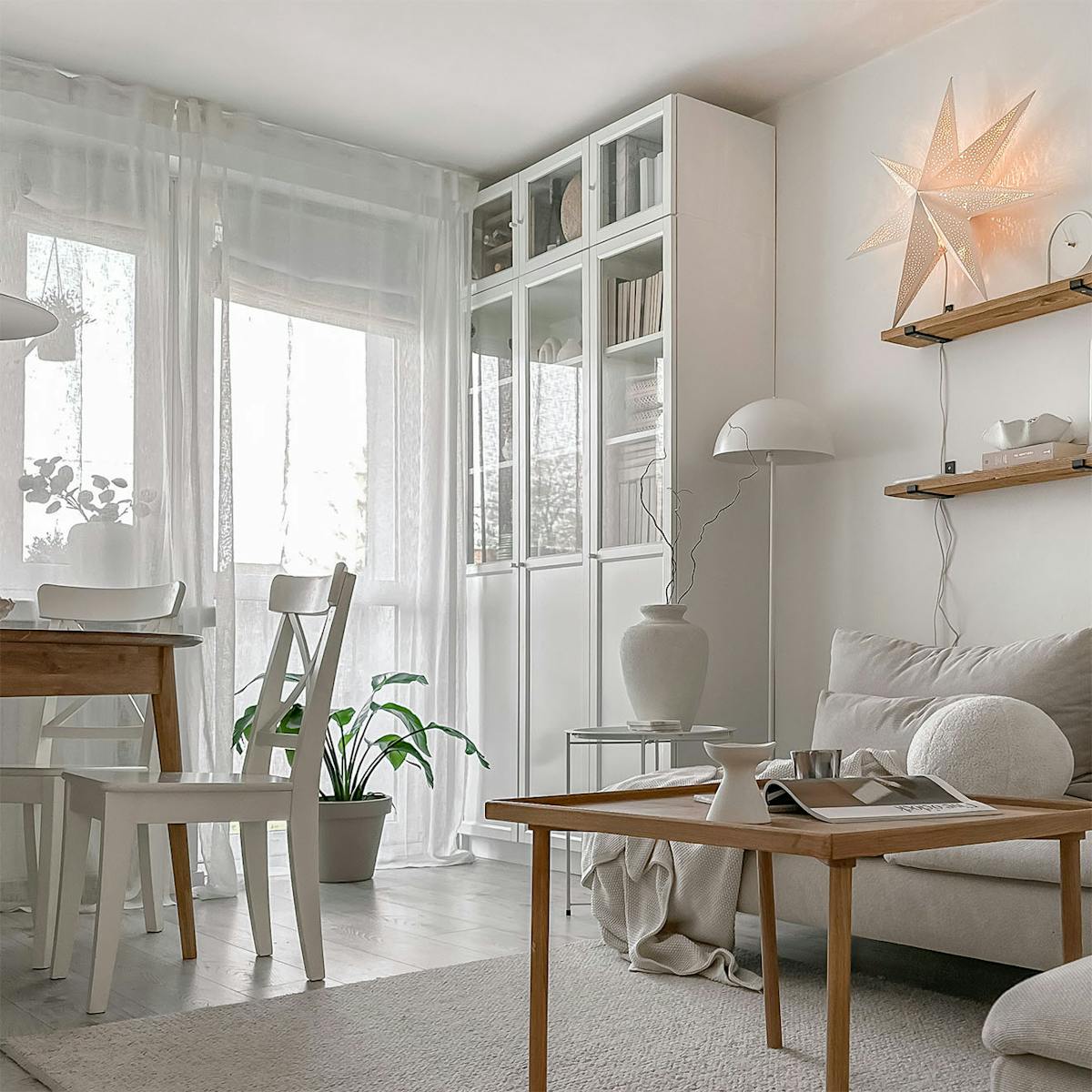 drewniany stolik kawowy, biała szafa z przeszkleniem w salonie w bloku