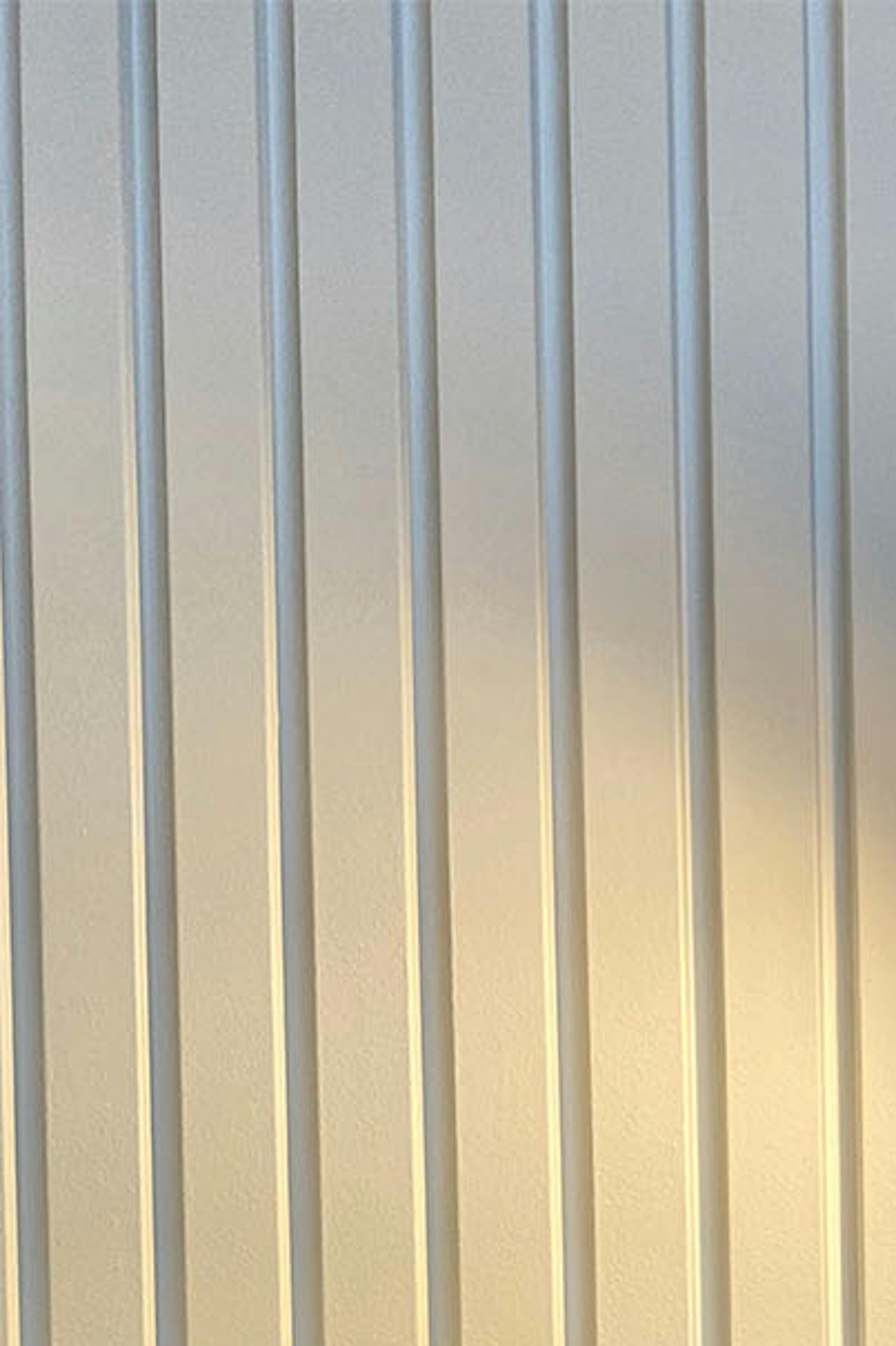stuc linéaire et lampe de chevet dorée dans la chambre d'un appartement moderne