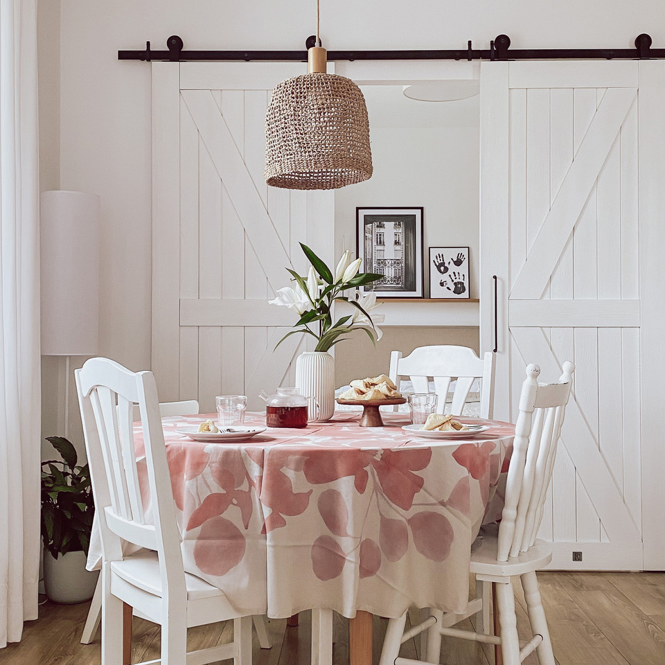 weiße Stühle am runden Tisch, Hängelampe im Boho-Stil, weiße Doppelschiebetüren im Schlafzimmer