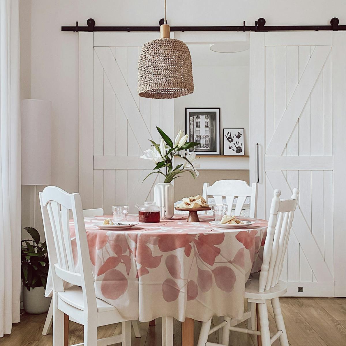 weiße Stühle am runden Tisch, Hängelampe im Boho-Stil, weiße Doppelschiebetüren im Schlafzimmer