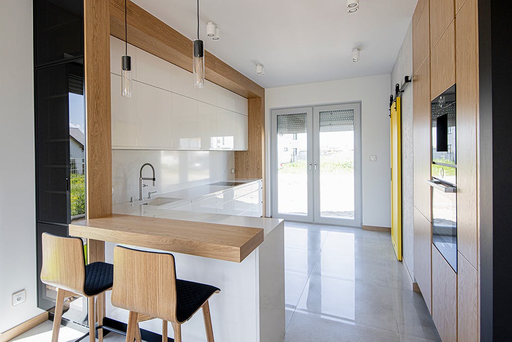 meubles de cuisine blancs finis avec du bois dans une cuisine moderne avec un garde-manger