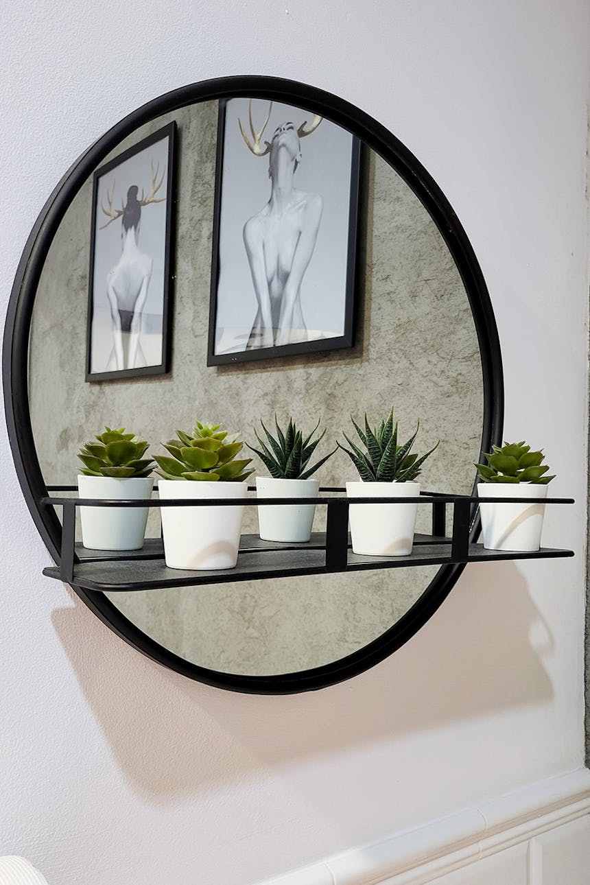 okrągłe lustro w czarnej ramce, z małą półką