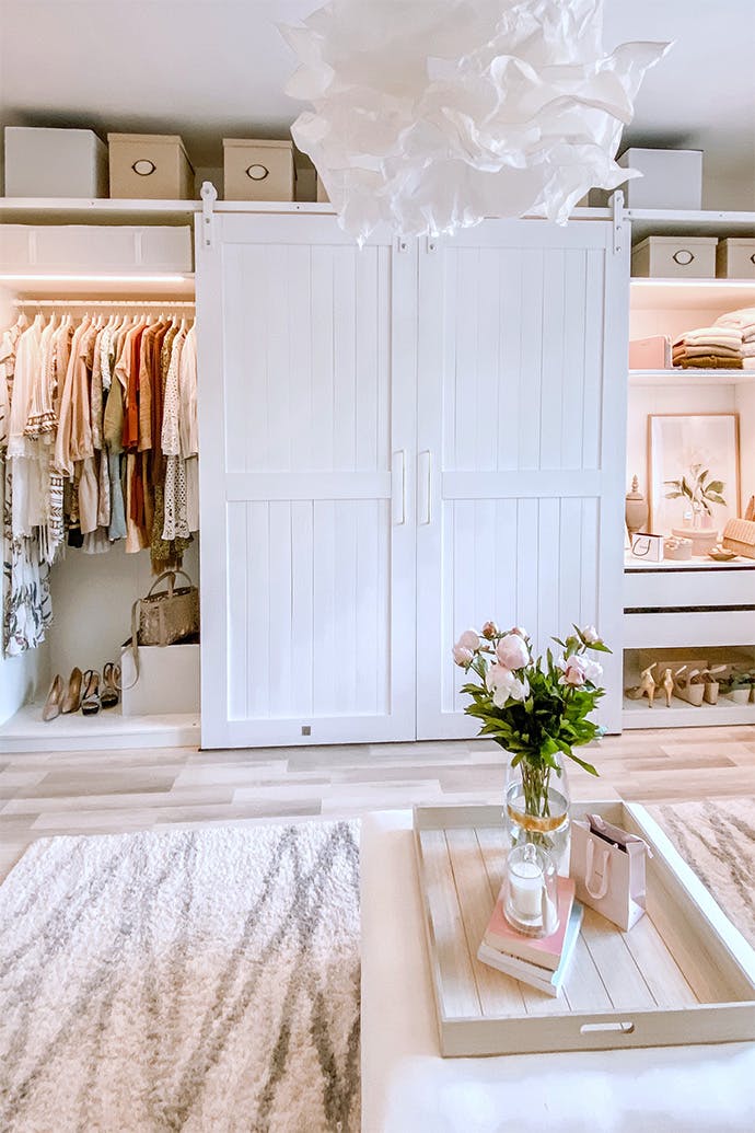 Portes blanches sur un système coulissant fermant l'armoire avec des vêtements