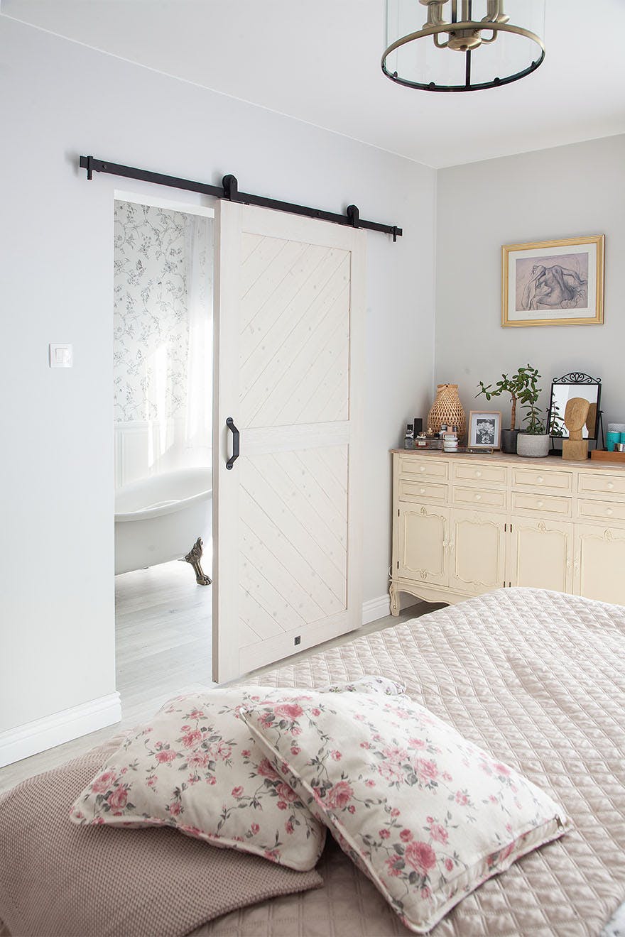 bathroom next to the bedroom separated by a white sliding door