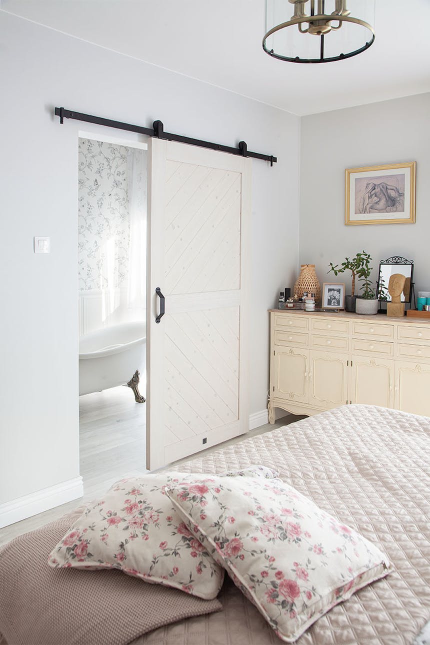 łazienka przy sypialni oddzielona białymi drzwiami przesuwnymi