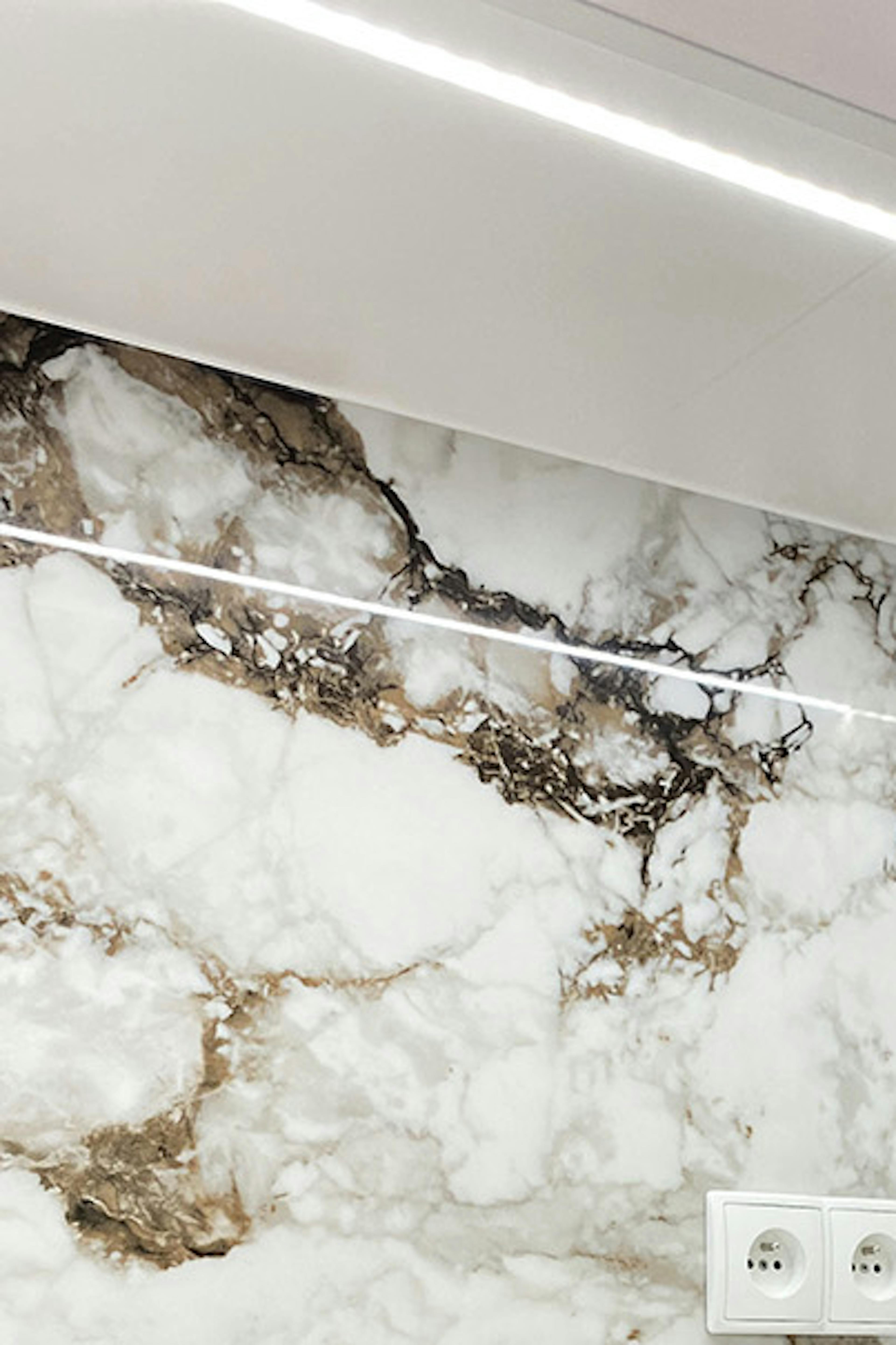 carreaux avec un motif en pierre au-dessus du comptoir d'une kitchenette lumineuse dans un appartement moderne
