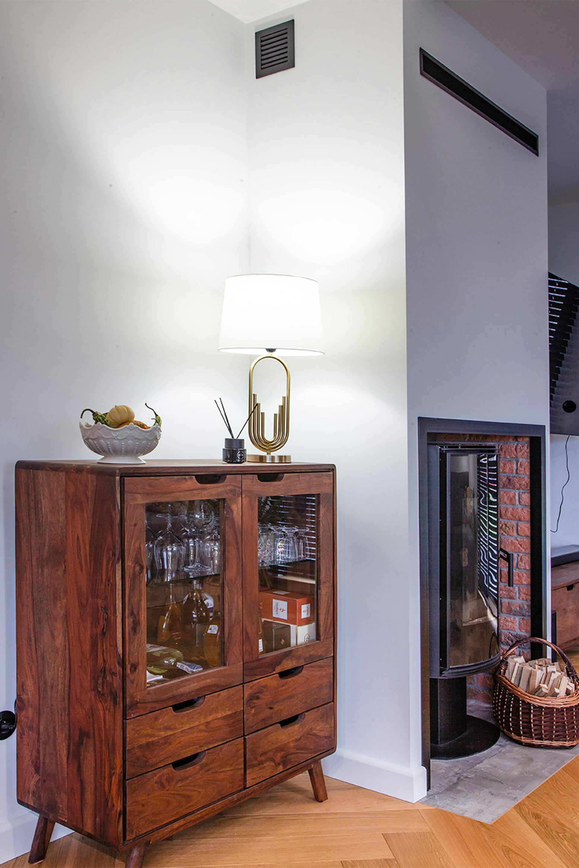 Holzvitrine mit Schubladen und Glasfronten vor einer weißen Wand