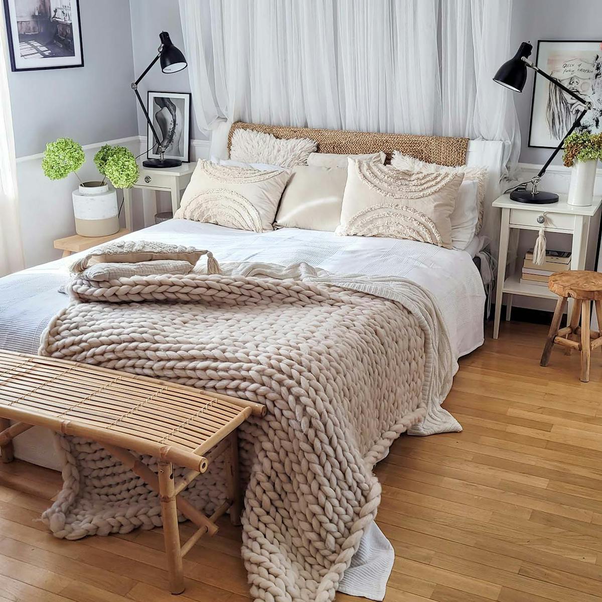 ein Doppelbett mit weißer Bettwäsche, einer dick gewebten Decke und dekorativen Kissen