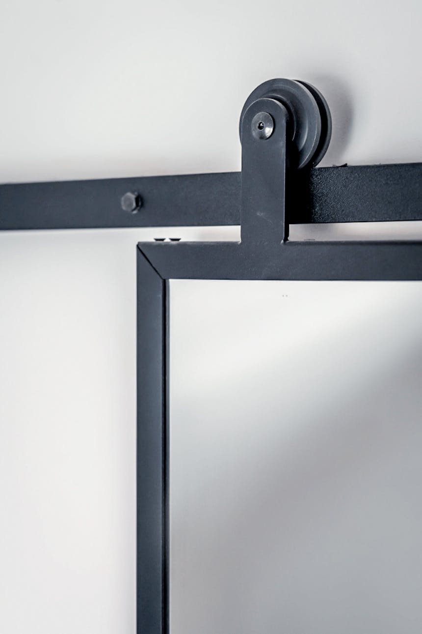 Schiebetür mit Spiegel in einem schwarzen Metallrahmen