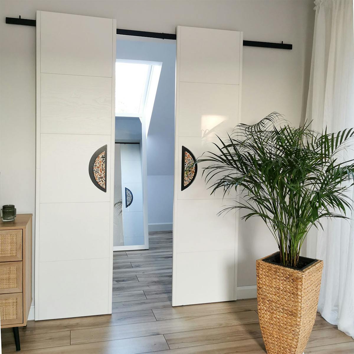 minimalistische, doppelte Schiebetüren mit großen Griffen, die einen kleinen Kleiderschrank schließen