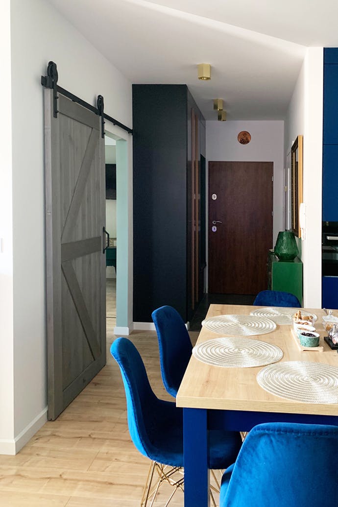 chaises bleues et portes coulissantes en bois gris dans un appartement moderne