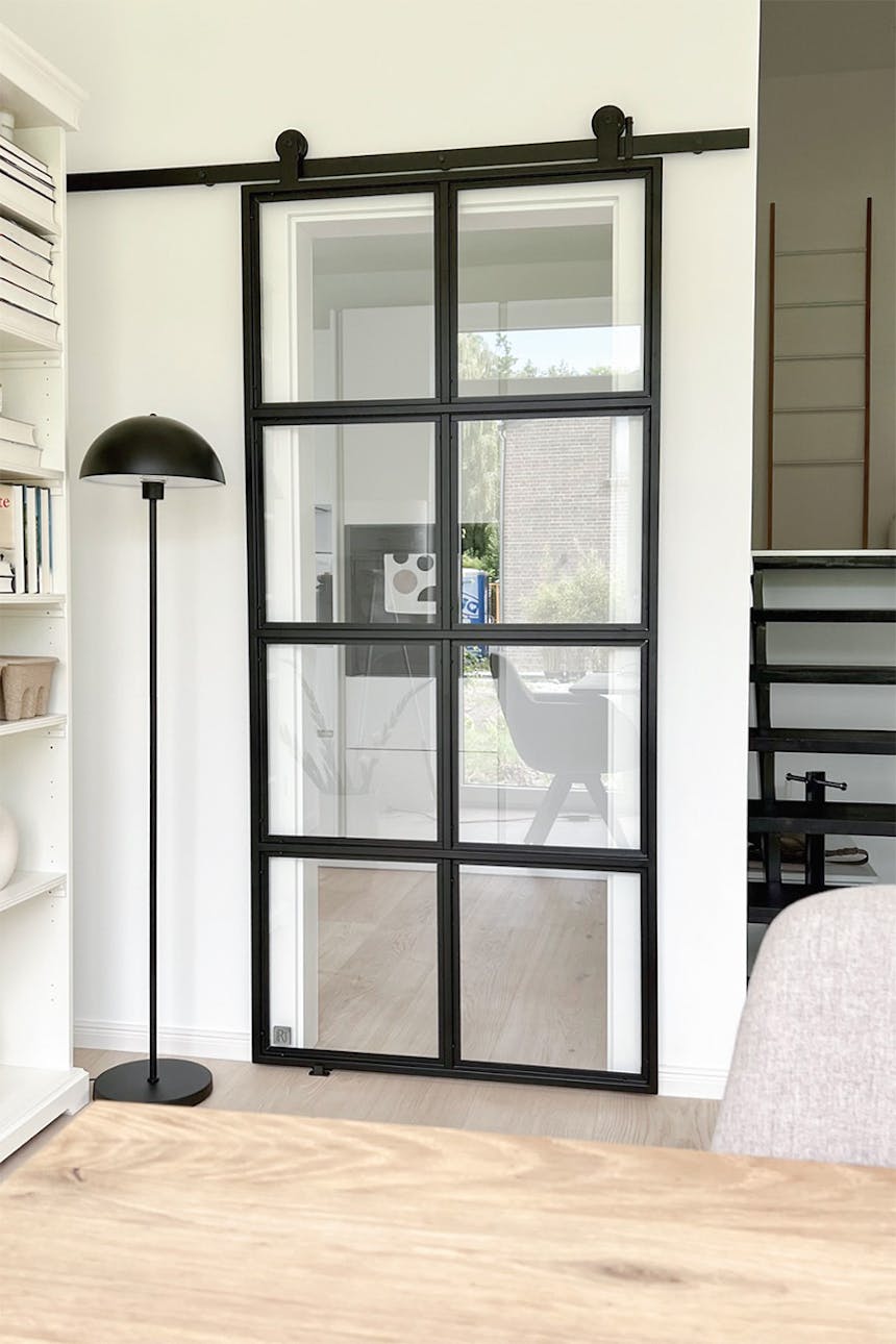Schiebetür mit Glas in einem Metallrahmen, industrielle Schiebetür für die Küche, schwarze industrielle Stehlampe