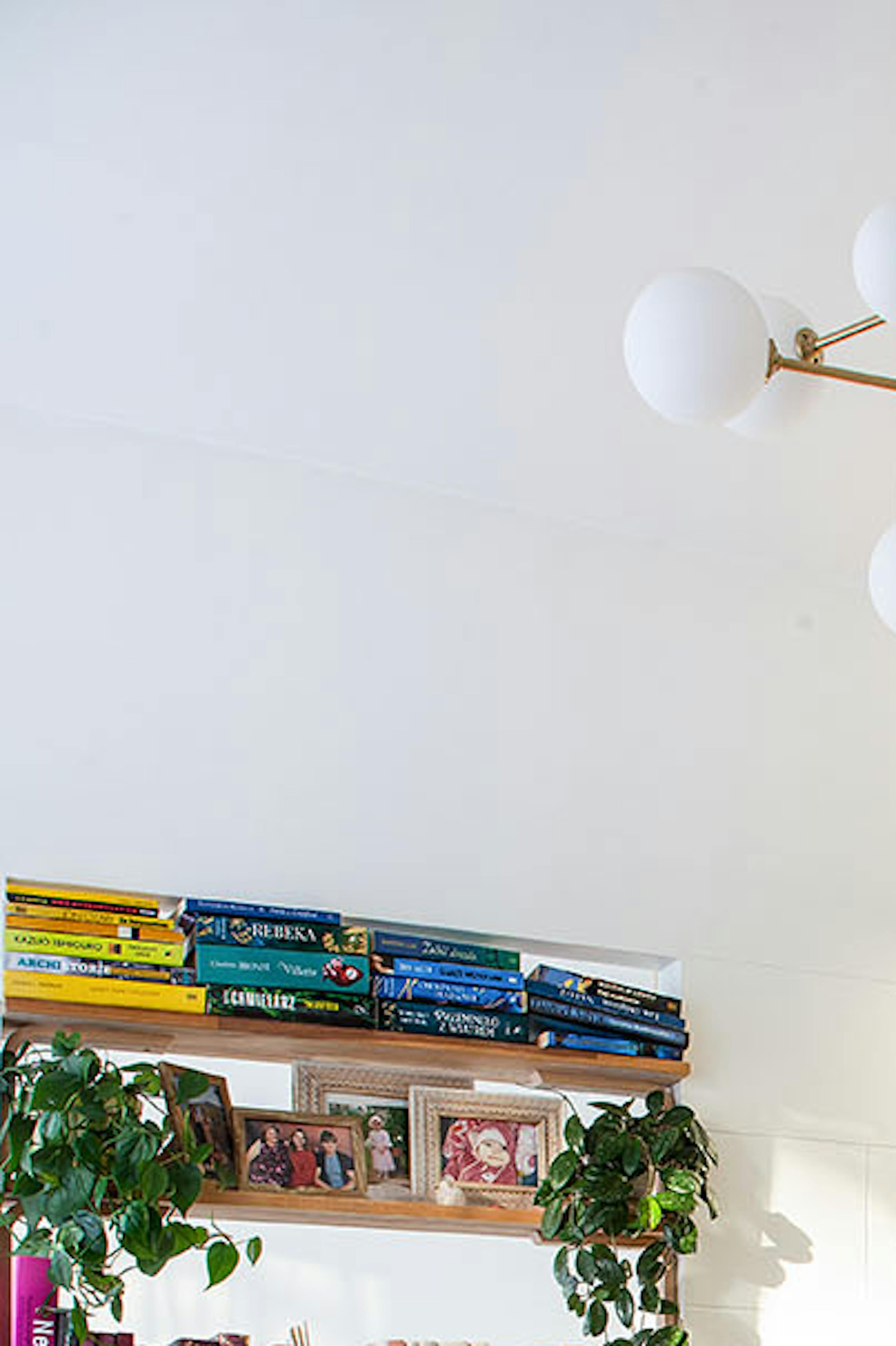 une table ronde en bois et une étagère avec des livres à l'intérieur d'un petit appartement