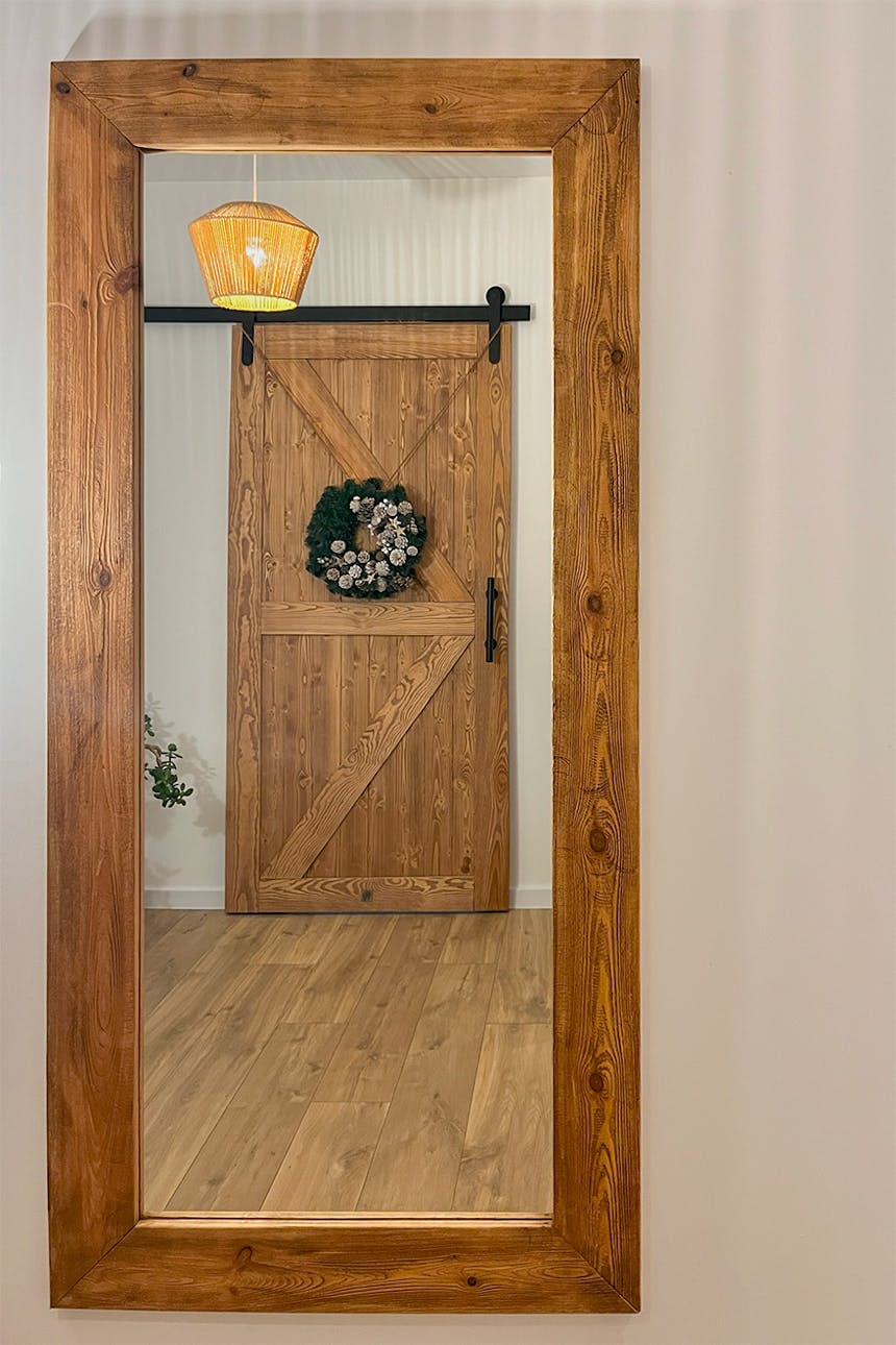 Holzschiebetüren und ein großer Wandspiegel in einem Holzrahmen