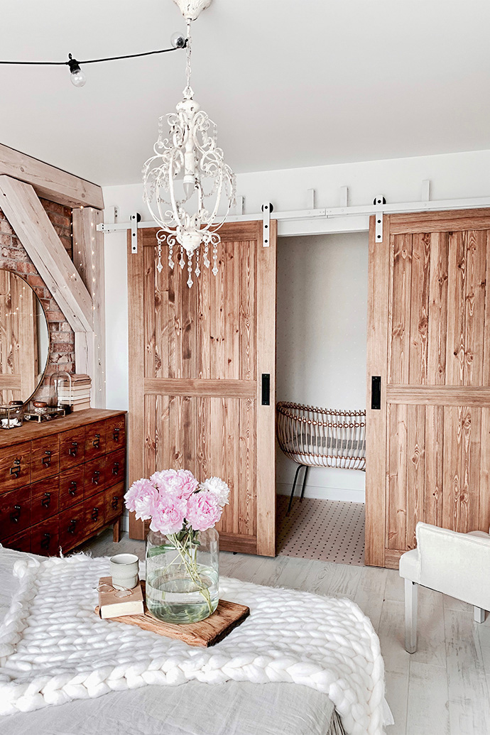 Rustikal Schlafzimmer, Holzschiebetür, Schiebetür, rustikaler Stil im Innenraum, moderner rustikaler Stil, Scheunen-Schiebetüren, weiße Schiebesystem, Bypass Schiebetüren, Bypass Wandhalterung für Schiebetüren, weiße rustikale Kronleuchter, Ziegel an der Schlafzimmerwand